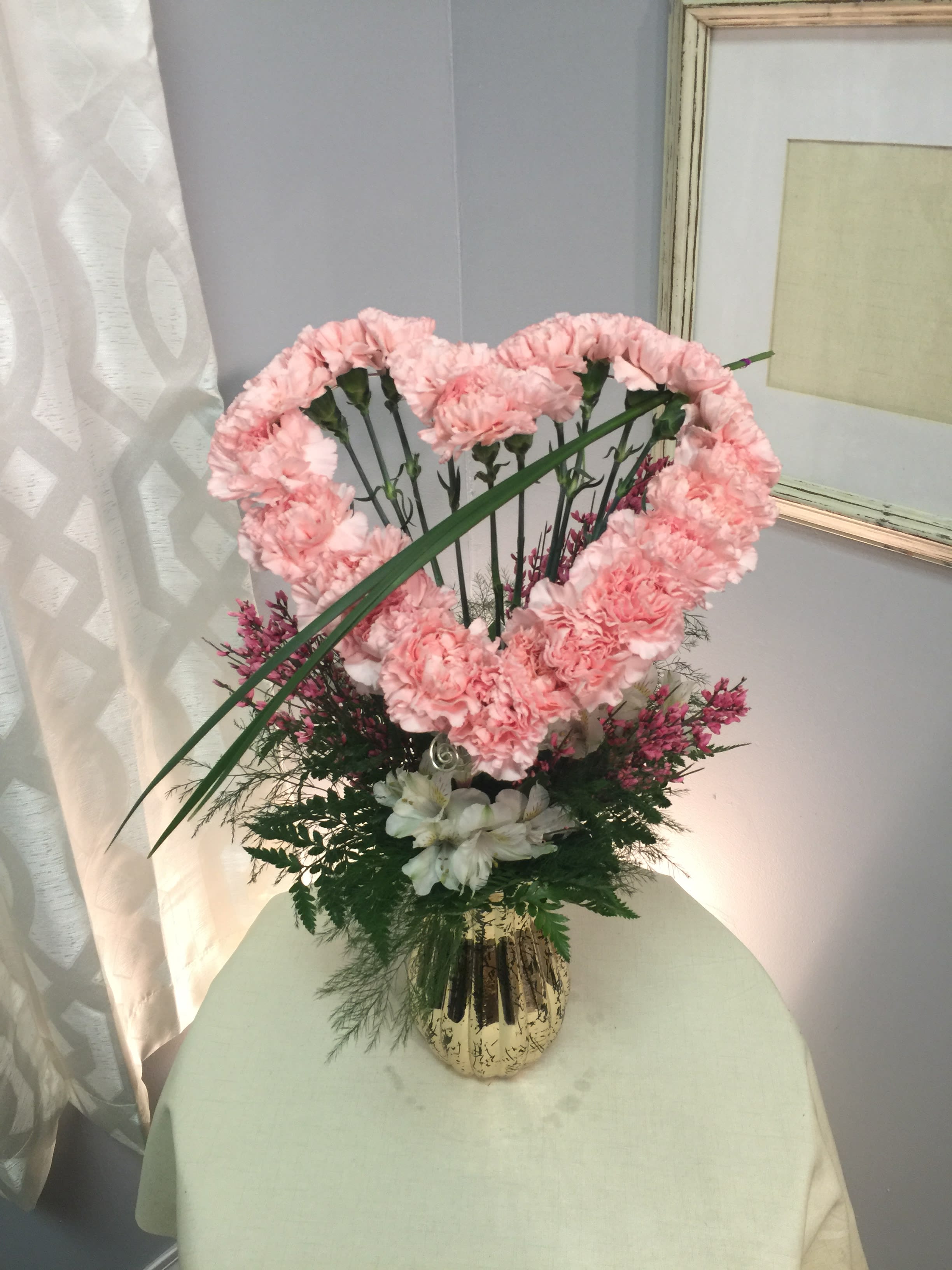 Allie &amp; Noah - Pink carnations made in the shape of a heart with pink accents and eucalyptus.
