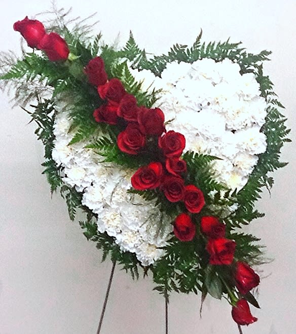 Bleeding Heart - Solid heart made of white carnations accented with lush greens with radiant red roses designed diagonally. 