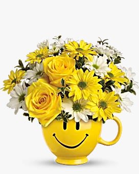 HAPPY FACE MUG ARRANGEMENT - Send smiles, receive smiles back. Send your loved ones bright yellow flowers inside a yellow smiley face mug. This personal keepsake mug is available to keep for a lifetime, bringing Joy to your loved ones forever. 