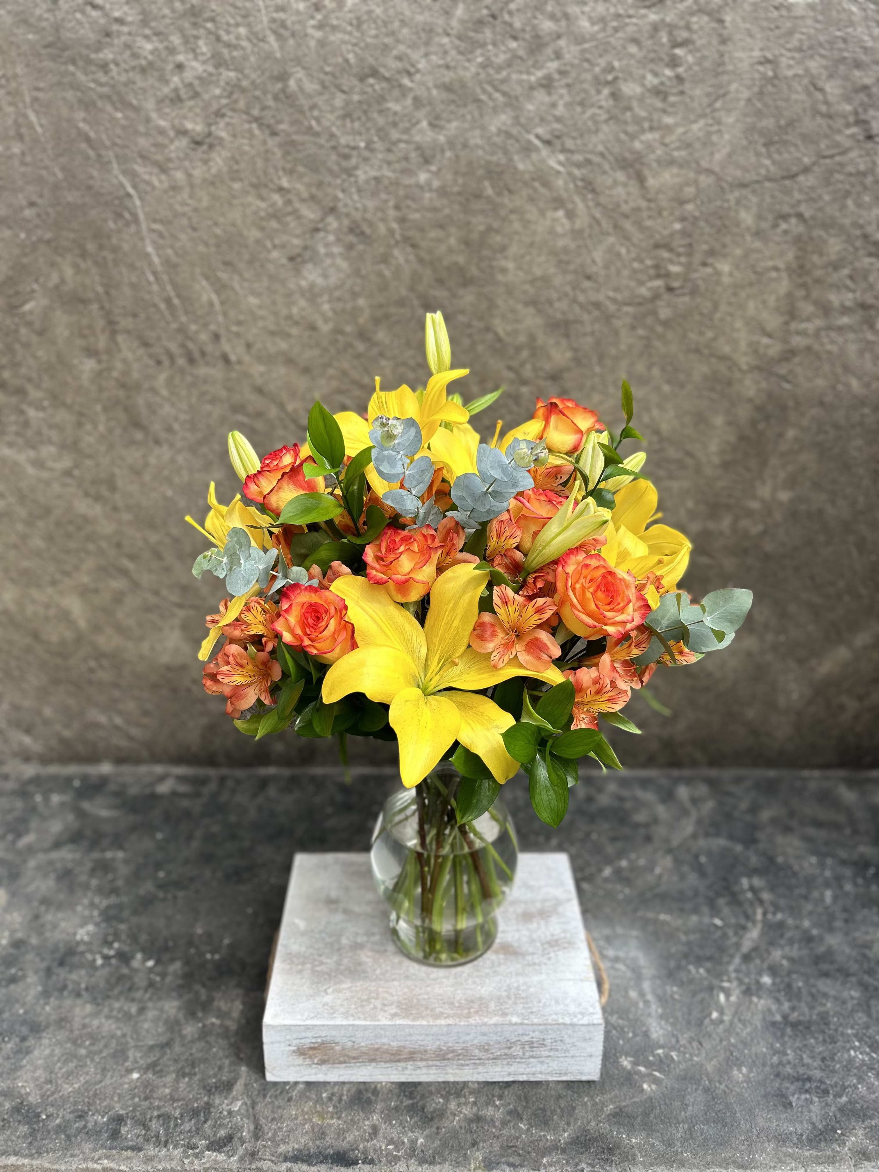 Susurru - Alstroemeria, lilies and roses in bright happy yellows and orange with eucalyptus.