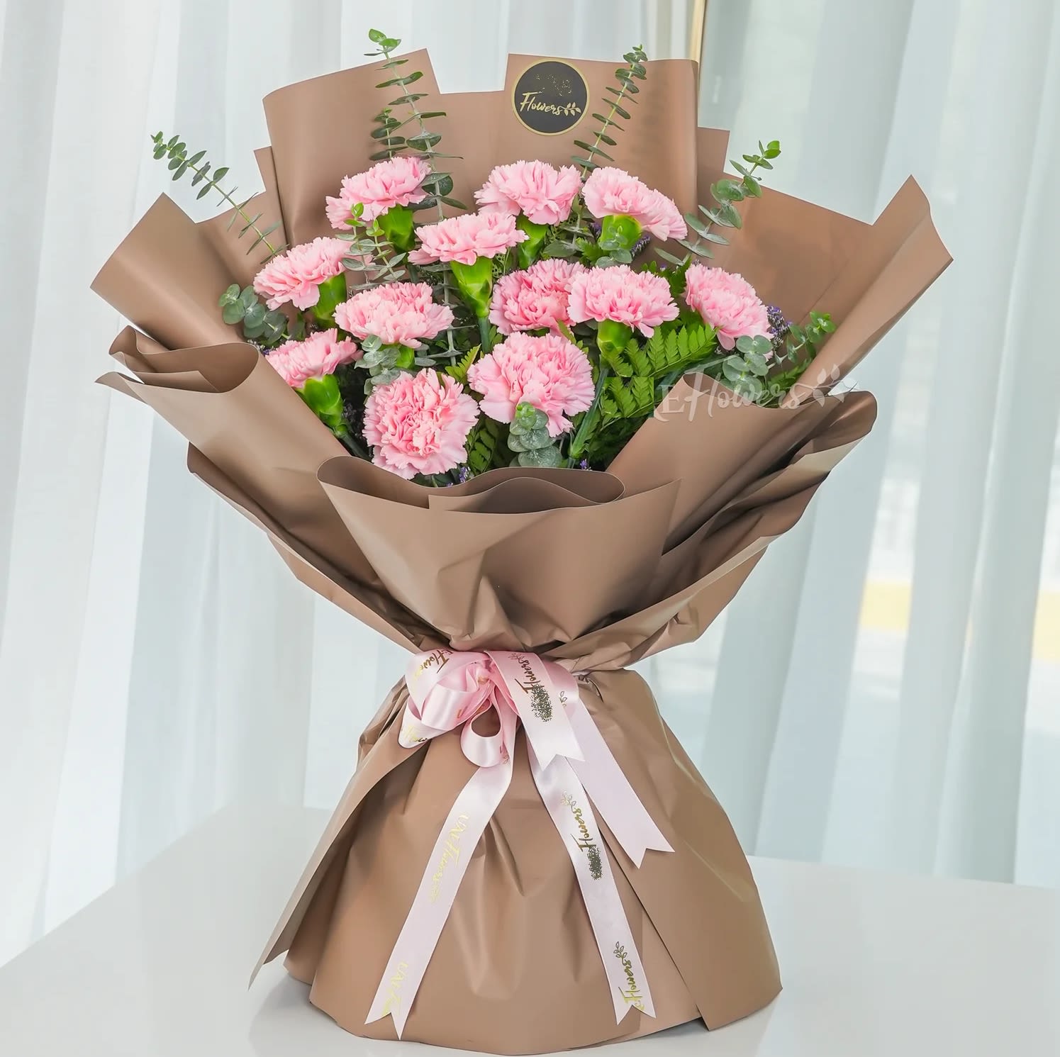 Soft elegant Pink Carnations - Soft, elegant, and full of charm, this delightful bouquet features 12 delicate pink carnations, beautifully accented with limonium and fresh green fillers. Wrapped in stylish paper and tied with delicate ribbons, this bouquet is a perfect choice for birthdays, anniversaries, baby showers, or simply to brighten someone’s day with warmth and love.