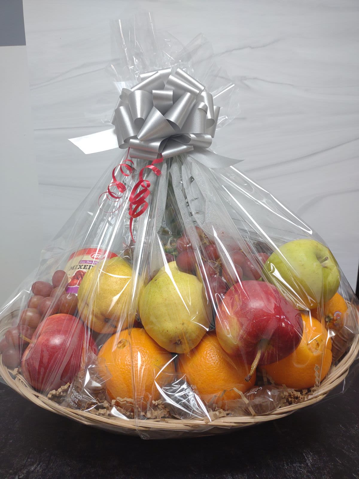 Medium Fruit Basket Medium Fruit Basket - Send a little sweetness with this medium sized fruit basket featuring seasonal fruit favorites with chocolate covered pretzels, mixed nuts and gourmet chocolates