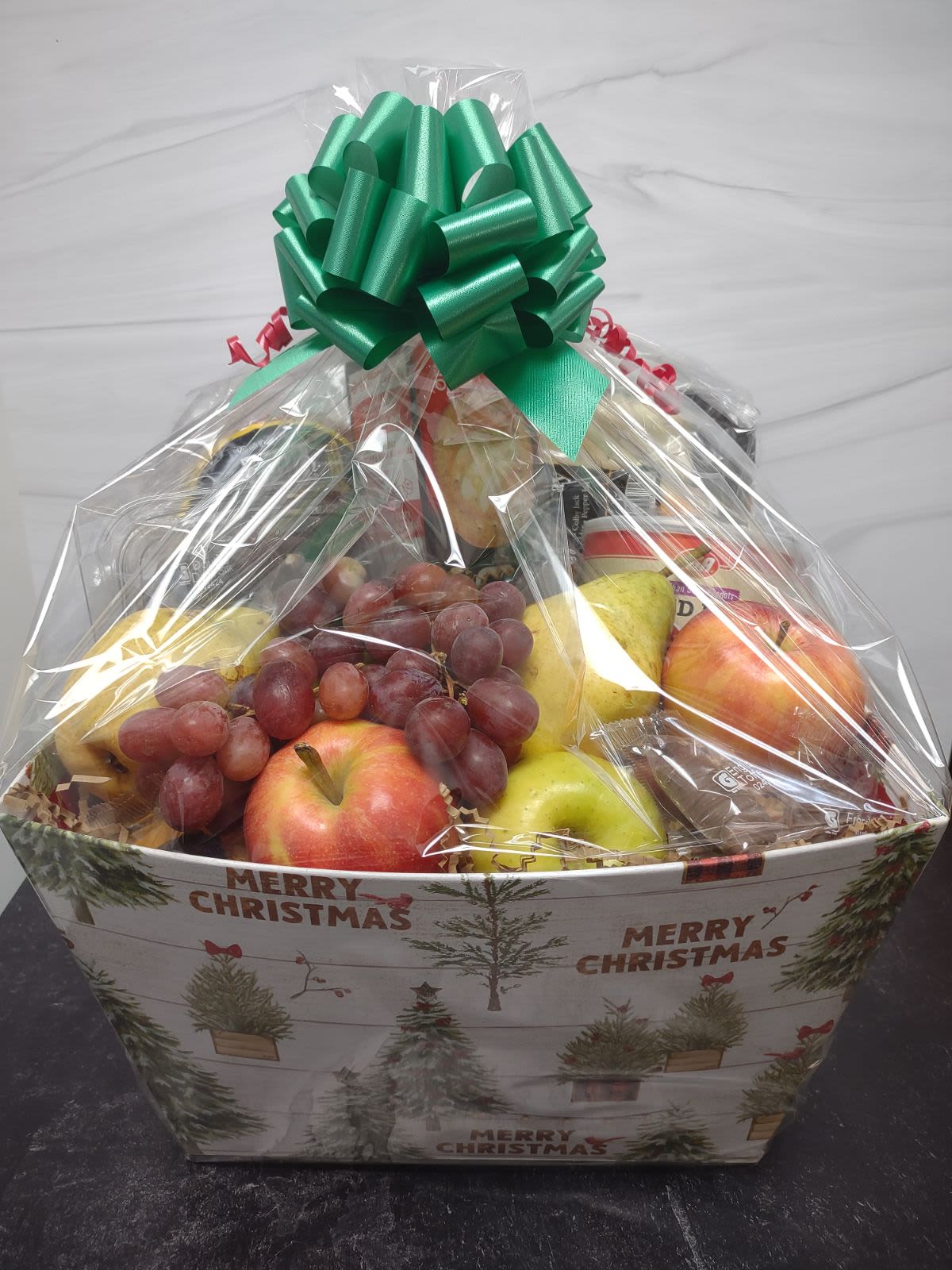 Large fruit basket with Trail& Cheese Large fruit basket with Trail& Cheese - Send some holiday cheer with this fruit basket filled with a large assortment of fresh fruits, mixed nuts, chocolate covered pretzels, Trail bologna, cheese assortment, crackers and gourmet chocolates.