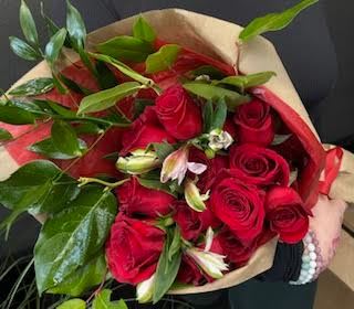 40 CM Dozen Red Roses Wrapped - A lovely hand-tied bouquet with a dozen red roses, and light pink filler flowers with textural foliage, ready to drop into a vase.