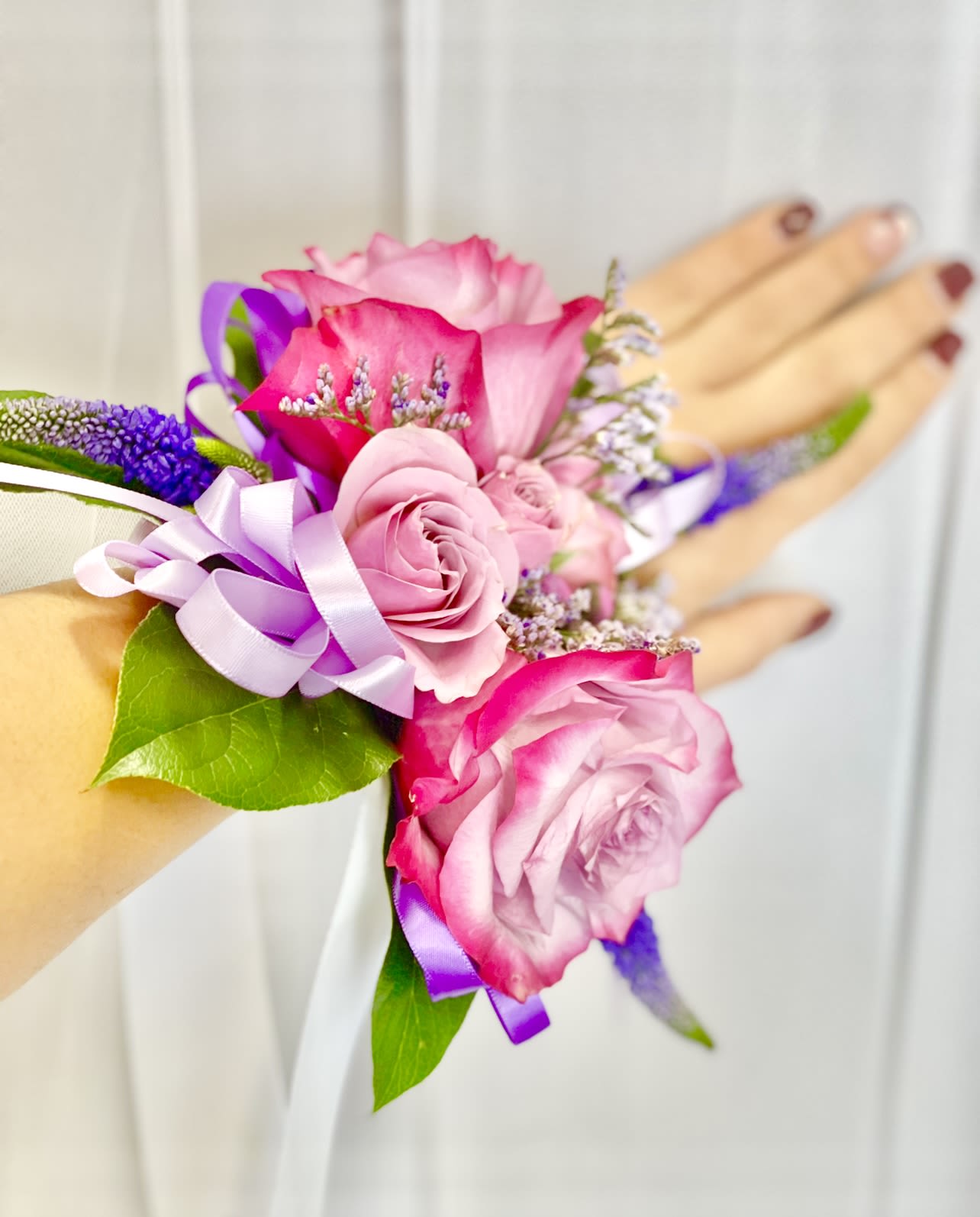 Lovely Purple Corsage  - Made from fresh flowers, a corsage looks like a petite flower arrangement (typically consisting of just one or several smaller blooms) and usually sits on the wrist like a bracelet, though it can also be pinned on a lapel. Corsages serve as a way to honor people who are very important to the couple getting married. Please contact our shop at (747) 249-4678 for any customization. 