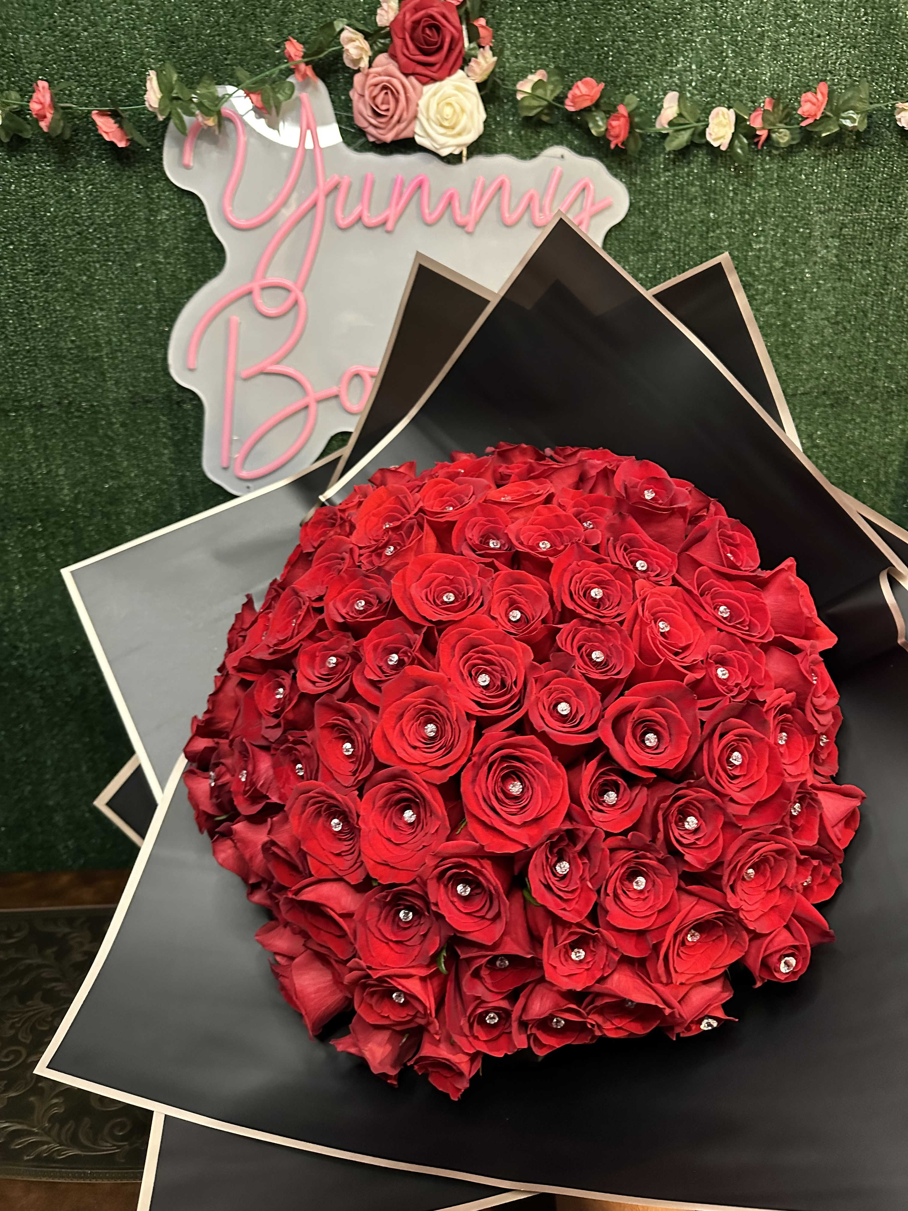 Buchon 100 Buchon 100 - 100 premium roses with or without crystal pins. Can choose color of roses and wrapping paper Picture is a reference every arrangement would not be exactly the same. Color Substitution may apply. Flowers and color substitution may apply" Does not include a vase
