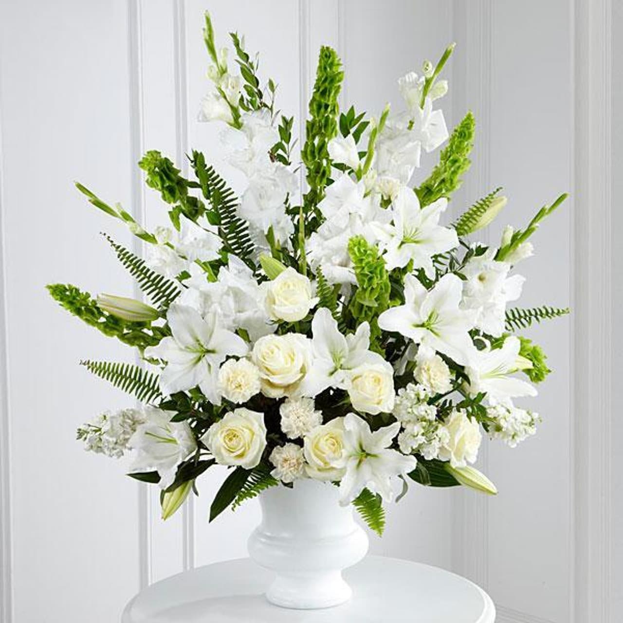  Morning Stars - Create an elegant and tranquil atmosphere with our all-white funeral arrangement, featuring a delicate blend of roses, lilies, carnations, snapdragons, and Bells of Ireland. This composition pays tribute to a life well-lived, exuding purity and reverence.