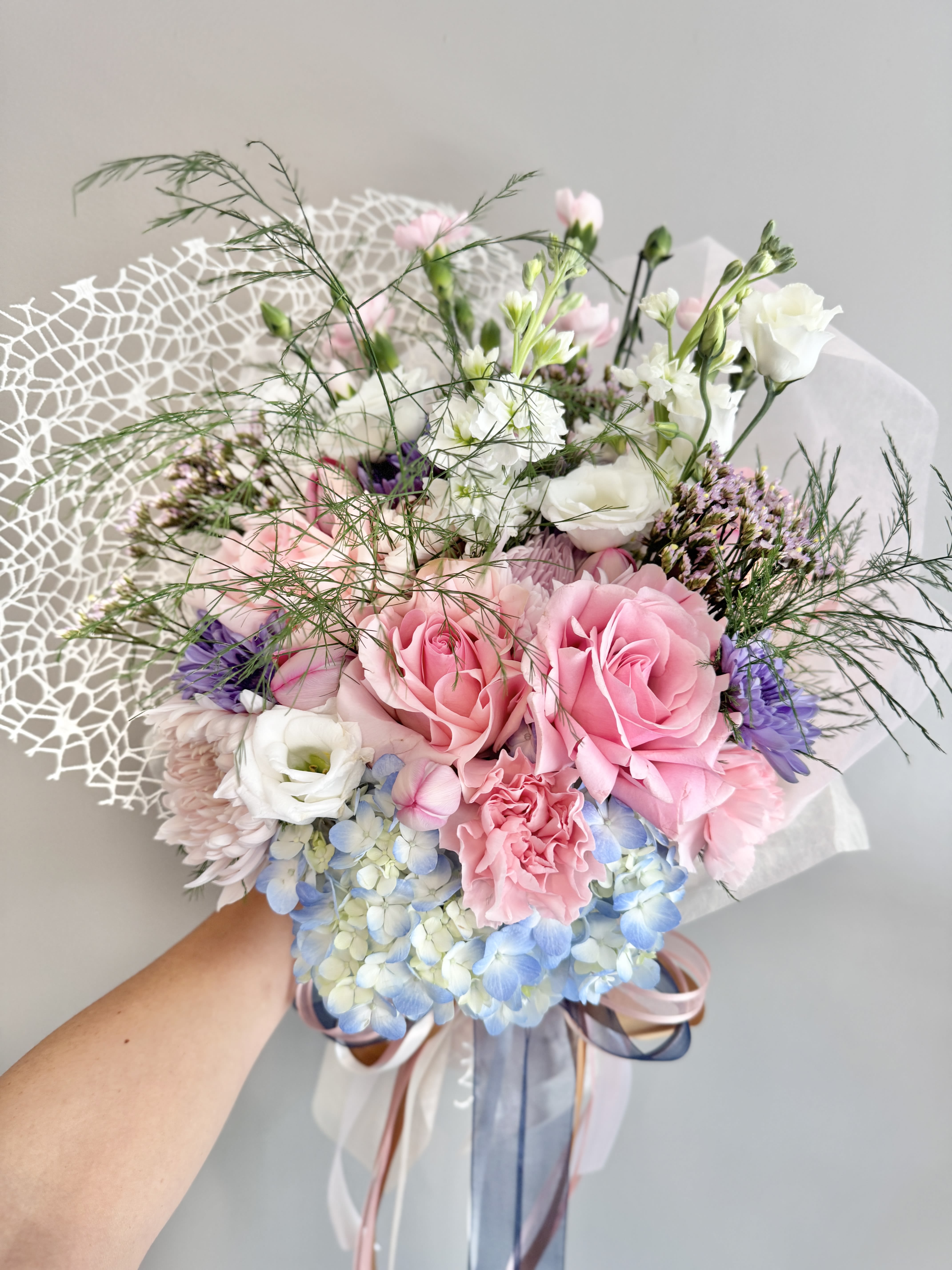 Wrapped Bouquet (Florist’s Pick)  - Celebrate life’s special moments with a seasonal bouquet designed by our florist’s expert eye. Each wrapped arrangement is one-of-a-kind, featuring a fresh mix of blooms and textures, elegantly tied with ribbon and ready to gift. Perfect for graduations, recitals, thank-yous, or just because—this bouquet brings beauty and joy to any occasion.  Please note: Flowers, colors, and wrapping vary based on seasonal availability and the florist’s creative direction.