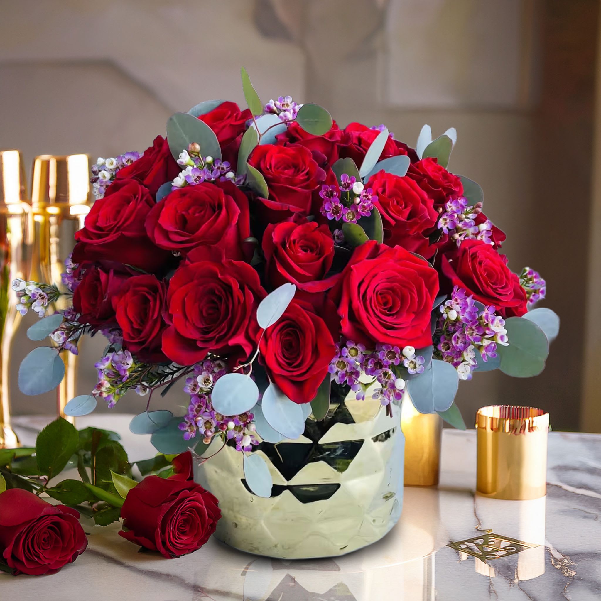 Gold 24 red rose pave pink wax Gold 24 red rose pave pink wax - A timeless expression of love, elegance, and luxury, this romantic red rose arrangement is designed to make a bold statement. Showcased in a reflective mirrored vase with a polished geometric finish, this composition features a lush dome of velvety deep red roses, artfully accented with sprigs of purple waxflower and silver eucalyptus. The saturated hues create stunning contrast while the clean, rounded shape keeps the design modern and refined. The gleam of the metallic container adds glamour, making this arrangement equally suited for romantic gestures or elevated interior styling. This floral piece is a top choice for anniversaries, Valentine's Day, luxury birthdays, and upscale romantic gifting. Whether placed in a chic bedroom, a candlelit dining space, or delivered to a stylish office, this arrangement delivers impact and intention with every bloom. Its classic beauty, elevated by premium design, makes it a best-seller for discerning clients. Touch of Orchids LA offers same-day delivery of this red rose arrangement throughout Los Angeles, including Beverly Hills, West Hollywood, Bel-Air, Studio City, and Century City. This piece is part of our Signature Romance Collection and a go-to for clients seeking dramatic florals with luxury flair.