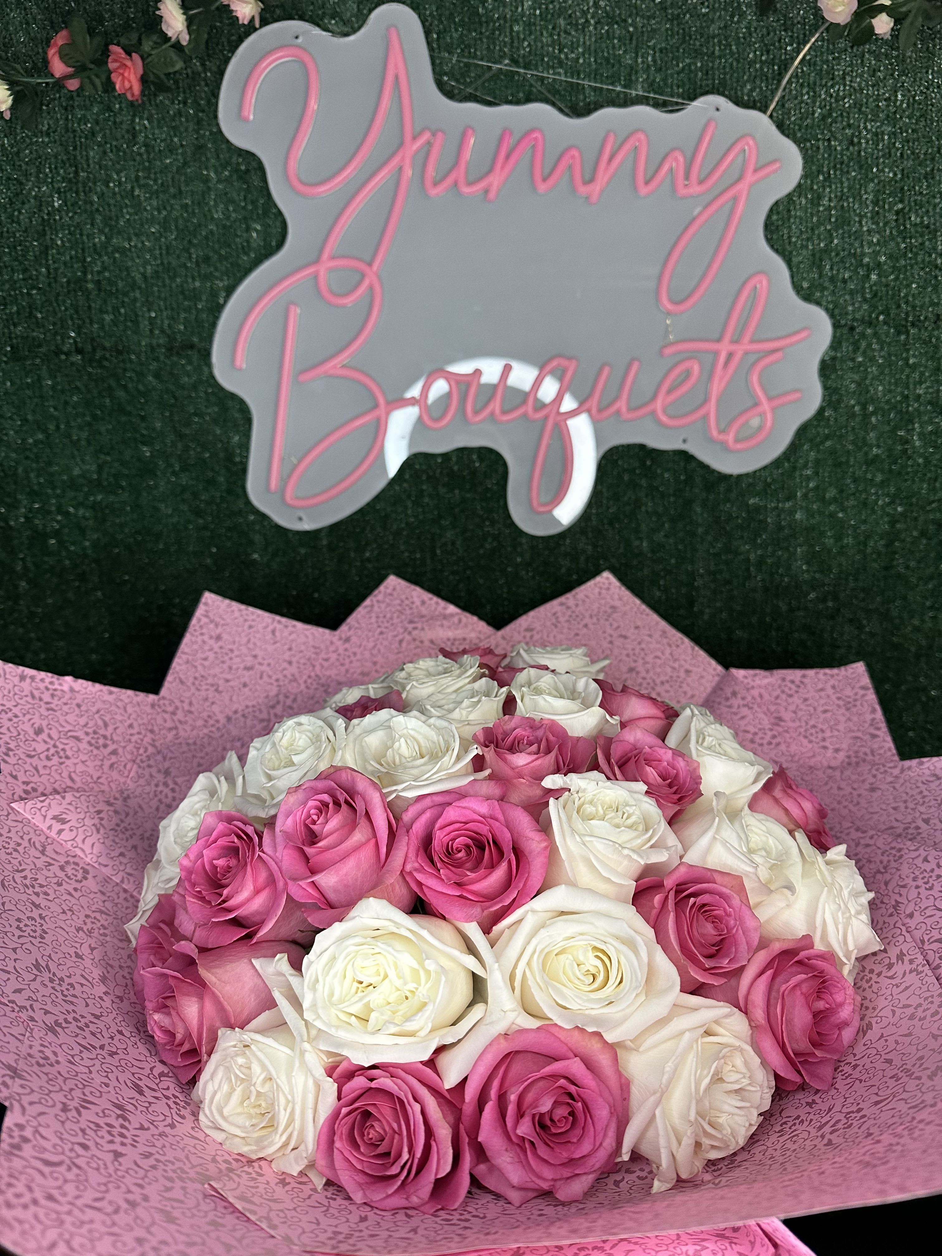Pink and white buchon - Standard 35 roses Deluxe 50 roses (picture) Does not include a vase Banner are additional  Picture is a reference every arrangement would not be exactly the same. Flowers and color substitution might apply.  