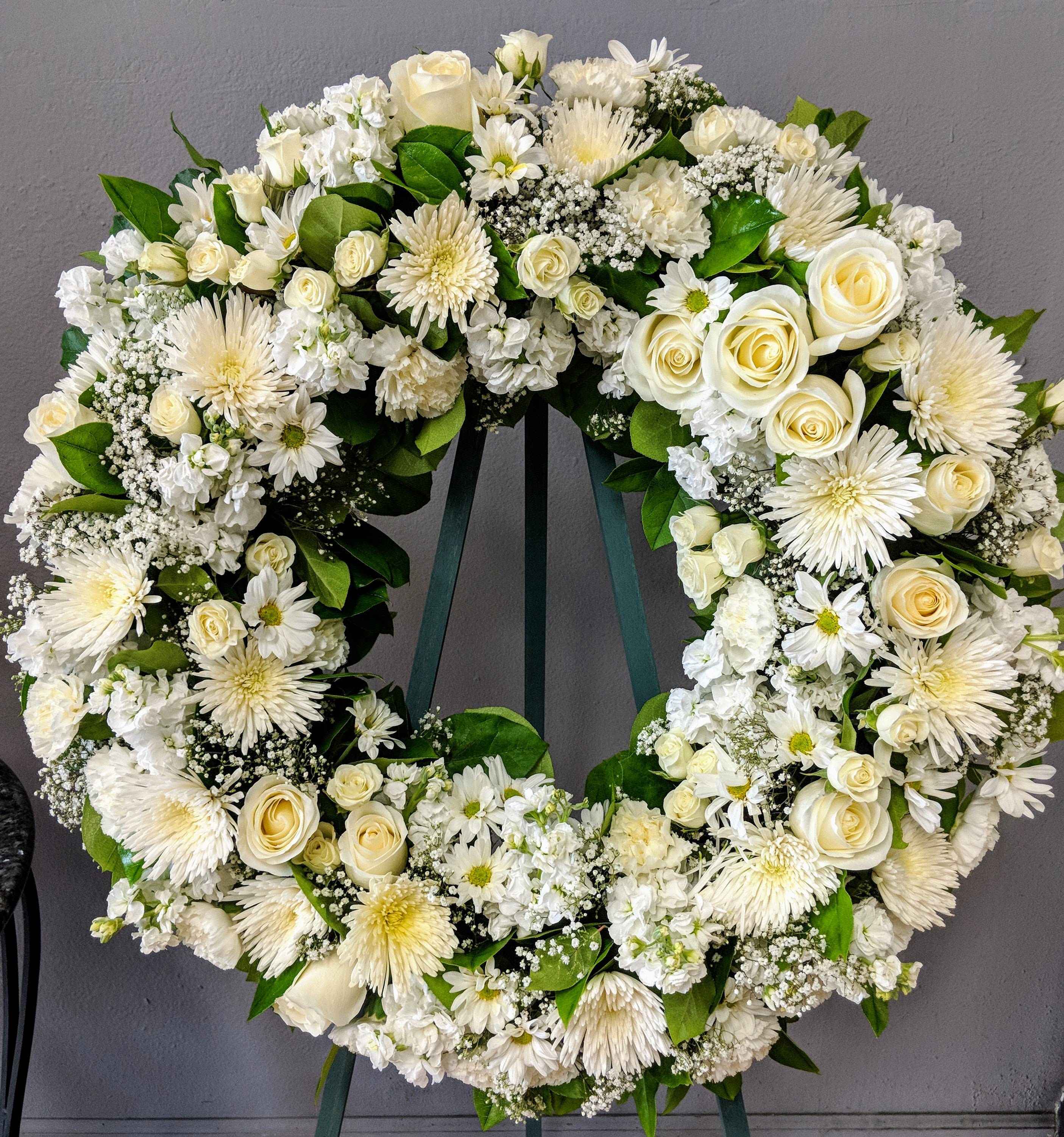 FUNERAL WREATH - Everlasting Life 9 - This is a classic option for funeral service, church or graveside. This open circle wreath will be designed with a circle form and will be delivered on a stand. This lovely mix of white roses, daisies, mums and carnations is an elegant way to send your thoughts and prayers.   **This is a piece for a funeral or memorial service. Please place the order at least 2 days prior to the service to guarantee a certain arrangement. Anything sooner and we cannot guarantee it will match the picture. These pieces can be customized to the color of your choice. The flowers may vary depending on availability of the flowers, special requests and quality of the flowers we have in stock. If you have a special request please add it to our special instructions when placing your order. If you have any questions please don’t hesitate to call. 714 289 1123**