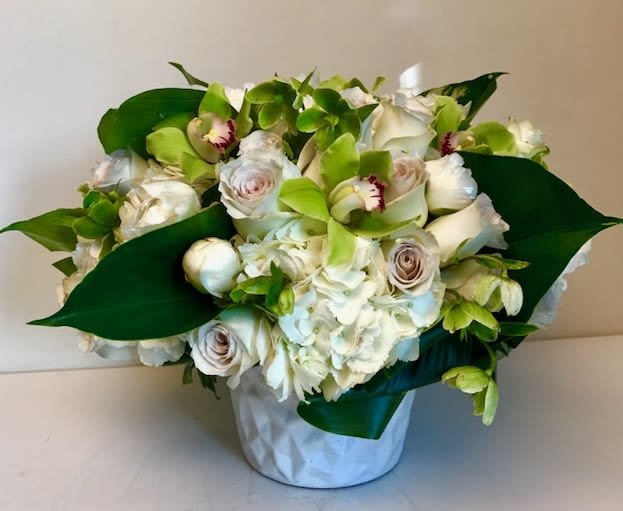 Stylish Spring Stylish Spring - Mixed floral arrangement with orchids, hydrangeas and roses with touches of greenery resting in white vase Some florals are seasonal, if particular flower will not be available due to season, we will substitute for similar flower, composition, color pallet and value of the arrangements as closely as possible. All effort to create a floral arrangement as close to the photo shown, the actual arrangement may vary slightly in its appearance from the photo shown. If you have any questions about your order, we welcome you to call us in or email