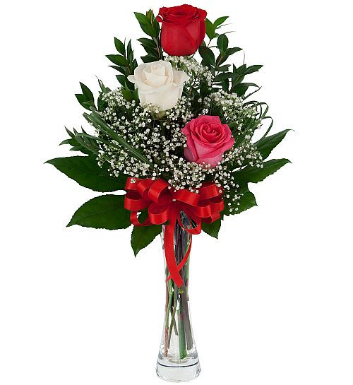 Rose Trio - Life is complicated enough. Sending roses on Valentine's Day shouldn't be. That's why our simple, elegant and expressive Rose Trio is a perfect Valentine's gift. Give her your love with this simple, elegant love-offering of 3 roses in red, white and pink, in a bed of greens and baby's breath, arranged in a classic glass bud vase with red ribbon.