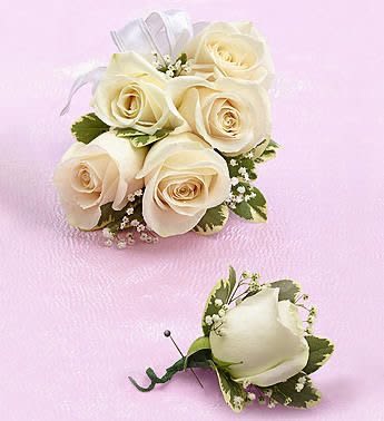 White Spray Rose Corsage and Boutonniere White Spray Rose Corsage and Boutonniere - Beautiful hand-designed corsage arrangement of white spray roses. Meant to be worn on the wrist. Paired with a matching, single stem white rose boutonniere to be worn on the lapel. Large corsage features 5 spray roses. Also Available in Other Colors. Call or Come by the Shop for Custom Orders.