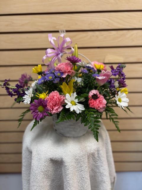 Sweetie Pie - Mixed cut arrangement with pink carnations, purple daisy, white daisy, yellow daisy, yellow Asiatic lily, and purple stock in basket with bow
