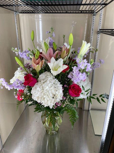 Dream - Mixed cut with white hydrangea, white lilies, pink lilies, lavender stock, hot pink roses, hot pink carnations, and pink wax flowers in a vase