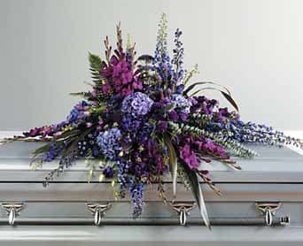 Purple Grace Casket Spray by Westford Florist Art by Veny Purple Grace Casket Spray by Westford Florist Art by Veny - Losing a loved one is an incredibly poignant moment, and honoring their memory with elegance is essential. The Purple Grace Casket Spray by Westford Florist Art by Veny serves as a heartfelt tribute, beautifully encapsulating the love and memories shared. This stunning arrangement features rich purples intertwined with soft whites and lush greens, reflecting both grace and dignity. Each bloom has been carefully selected to convey profound emotion, ensuring that your final farewell resonates deeply with all who gather to celebrate a cherished life. Trust Westford Florist Art by Veny to help you create a personal and meaningful homage during this difficult time. Crafted with care by our skilled team at Westford Florist, this timeless arrangement exudes sophistication and beauty. Whether displayed at a funeral service or placed upon the casket during burial or cremation ceremonies, the Purple Grace Casket Spray will serve as a poignant reminder of your lasting love for your dearly departed. Choose the Purple Grace Casket Spray as your final gift to honor your loved one’s life well-lived. Let its serene colors and exquisite design bring comfort and peace during this difficult time. Order yours today from Westford Florist to pay a heartfelt tribute to your cherished loved one.