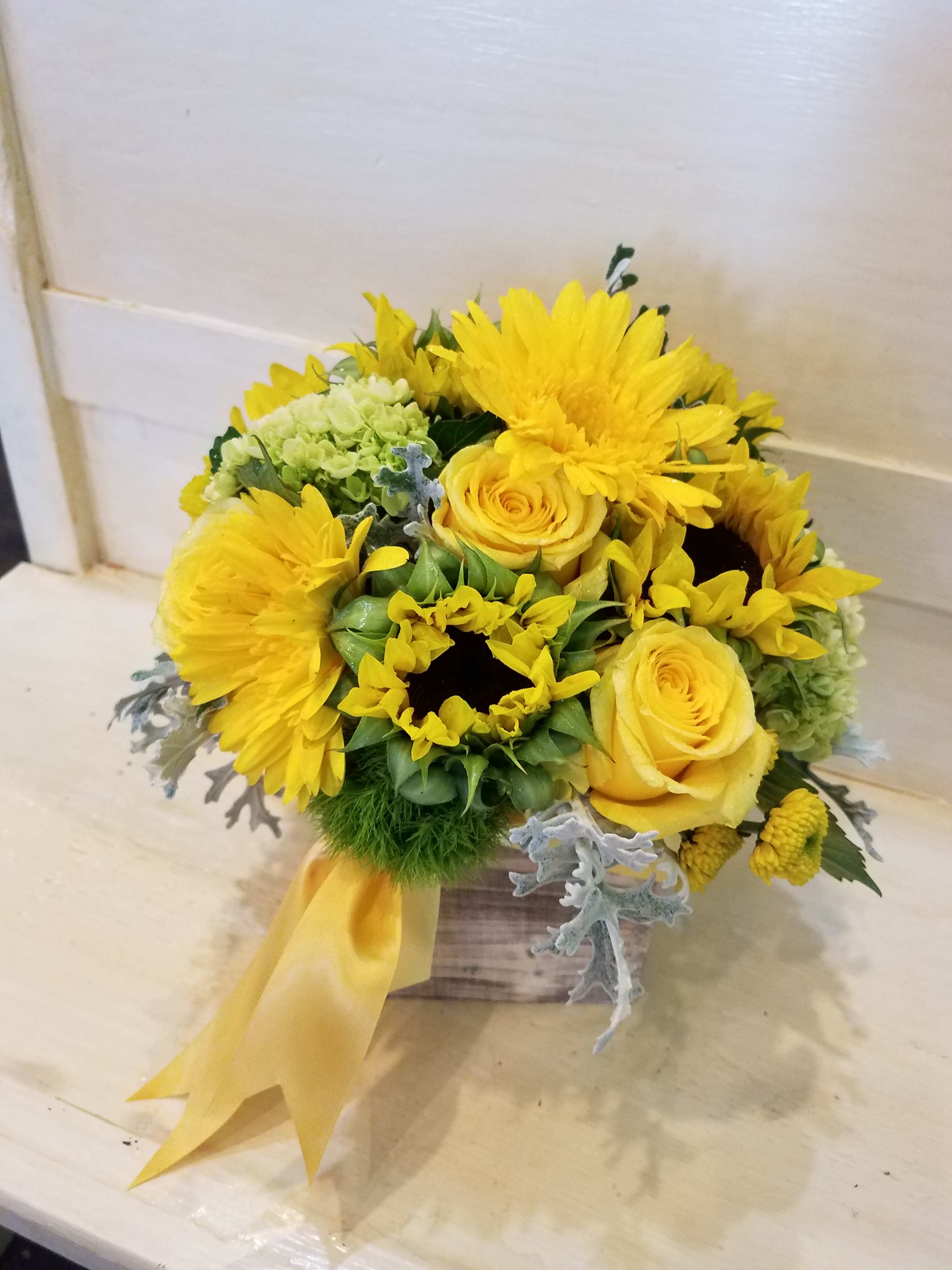 Sunny Days Ahead - Need to send happiness and cheer? This bright arrangement is sure to please with Fresh sunflowers, yellow Gerbera, green hydrangea, yellow buttons and more arranged in a Barnwood box, complete with yellow satin ribbon. Perfect for any occasion. 