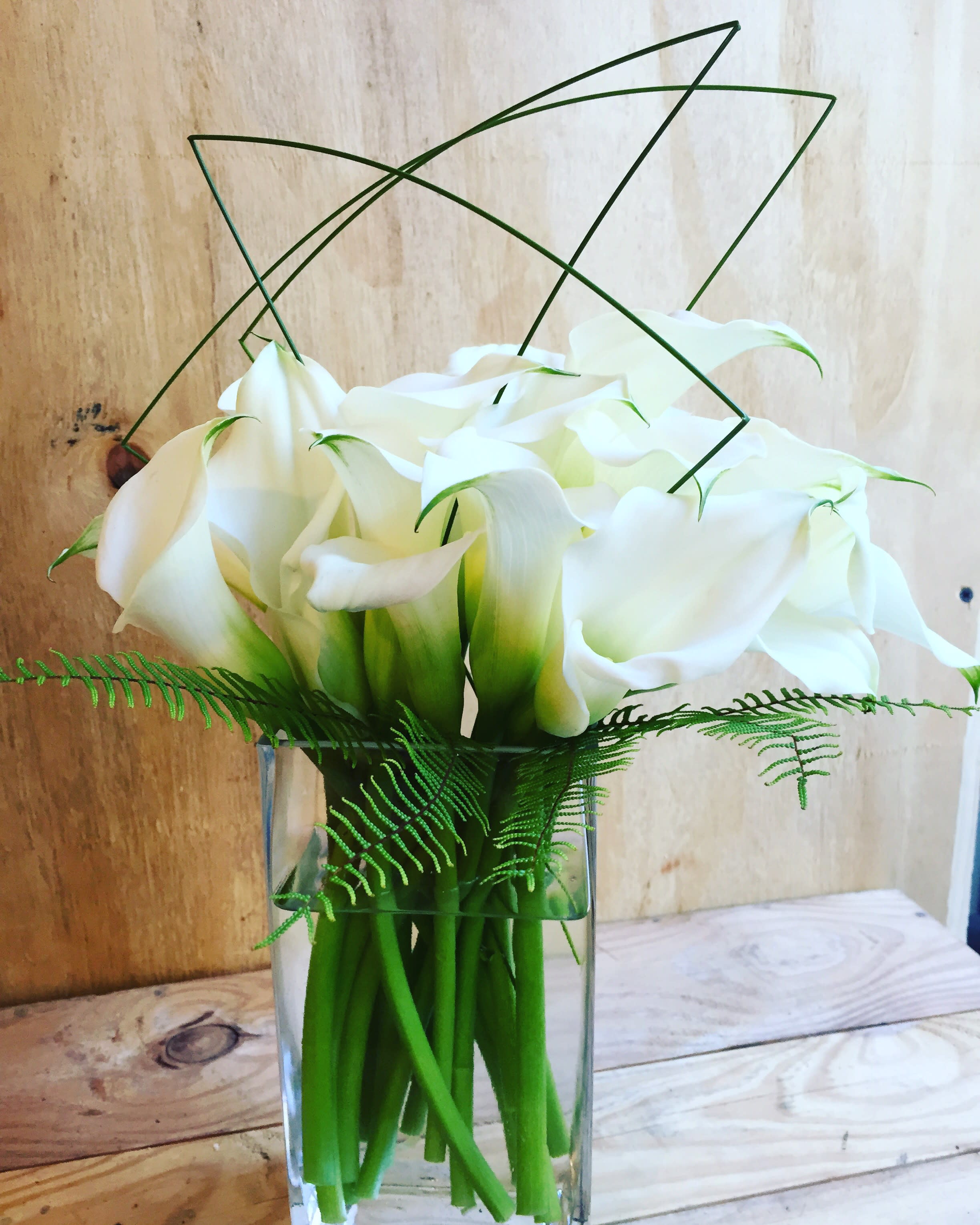 The Modern - White callas with steel grass. This may not be available for same day delivery. Also available in burgundy, pink and yellow. Please message us in the special instructions. Best florist nyc.