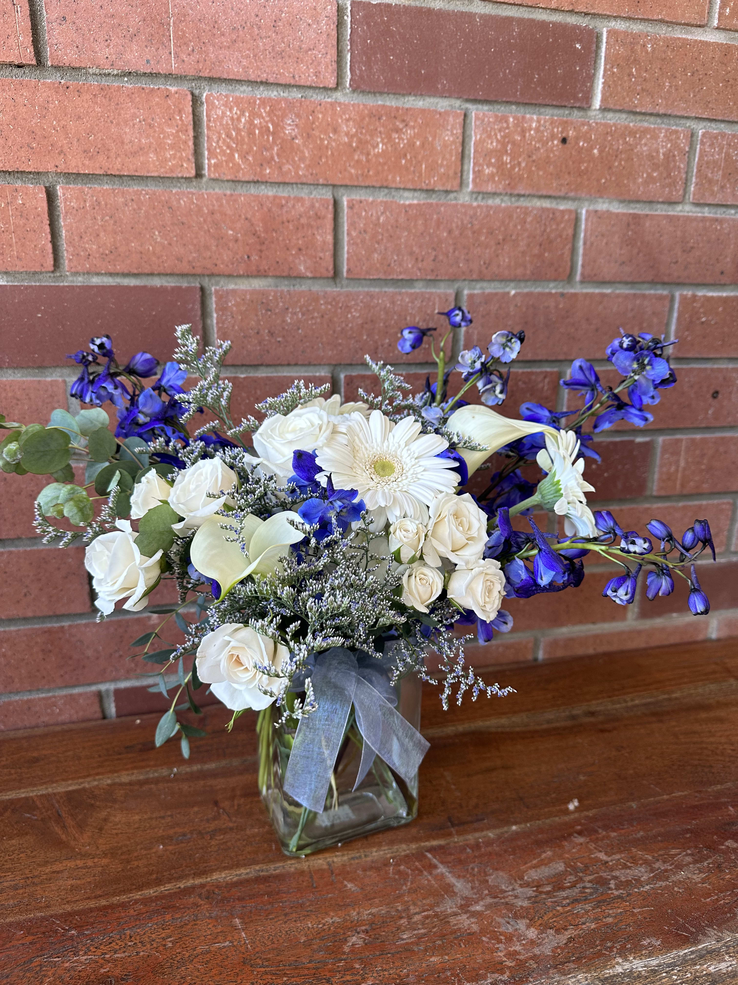 The Blue Bouquet  - Lovely arrangement of fresh flowers with classic whites and vibrant blues in a clear vase with premium fillers and greenery accented with a bow.