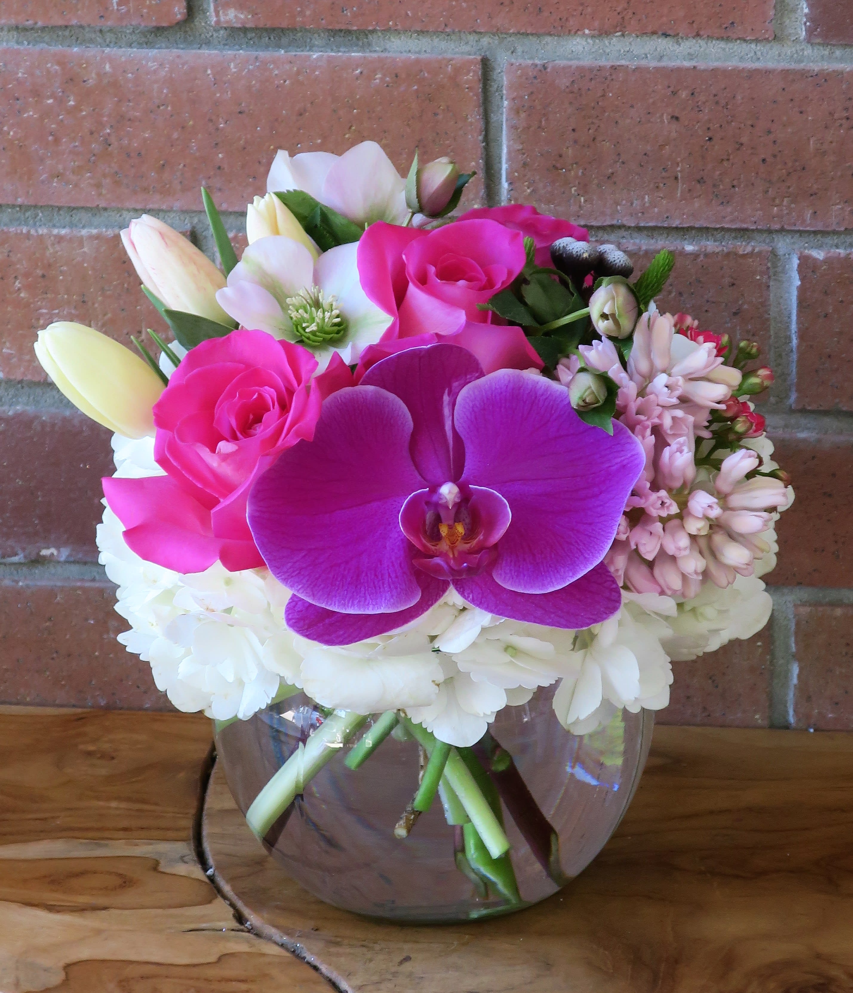 Lovely Day Bouquet - Arrangement of purple orchids, white hydrangea, bubble gum pink roses, tulips and lush fillers in a bubble bowl. 