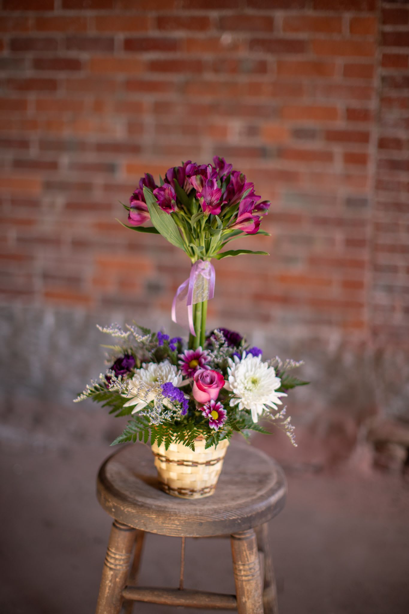 Alstroe-Topiary - A fun favorite floral design. Colors will vary based on inventory. Long lasting alstroemeria flowers are arranged in the shape of a cute tree. A whimsical design and great value. The &quot;tree,&quot; is in the center of a lovely garden array of seasonal blooms of dianthus, roses and mini carnations. Seasonal ferns, foliage and accent flowers complete the design. Featured photo shows design in purples and whites. Color combinations may include pinks and whites, pinks purples and whites, purple and white or citrus tones (yellow, orange, limes and white) Please let us know your preference we will do our best to accommodate. Please be mindful that during major holidays requests may not be available. Arrangements is about 15-22 inches in height.