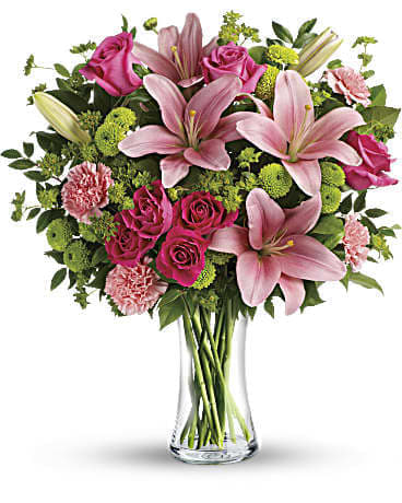 ***5 Day Notice***Dressed To Impress ***5 Day Notice***Dressed To Impress - What's better than pink? More pink! Lavish AMERICA'S FAVORITE MOM® with this blissful bouquet of roses and lilies, hand-delivered in a classic glass vase. It's an impressive gift that promises to put some pink in her cheeks! This fabulously feminine bouquet features hot pink roses, hot pink spray roses, pink asiatic lilies, pink carnations, green button spray chrysanthemums, bupleurum, huckleberry and lemon leaf. Approx. 17 1/2 W x 20 H Delivered in a clear glass vase. Orientation: One-Sided