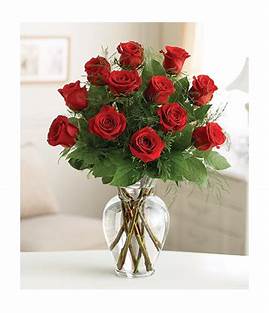 Dozen Red Roses - One dozen red roses in a clear vase with greenery. Great for Anniversaries, Valentines Day or a great way to say I love you.
