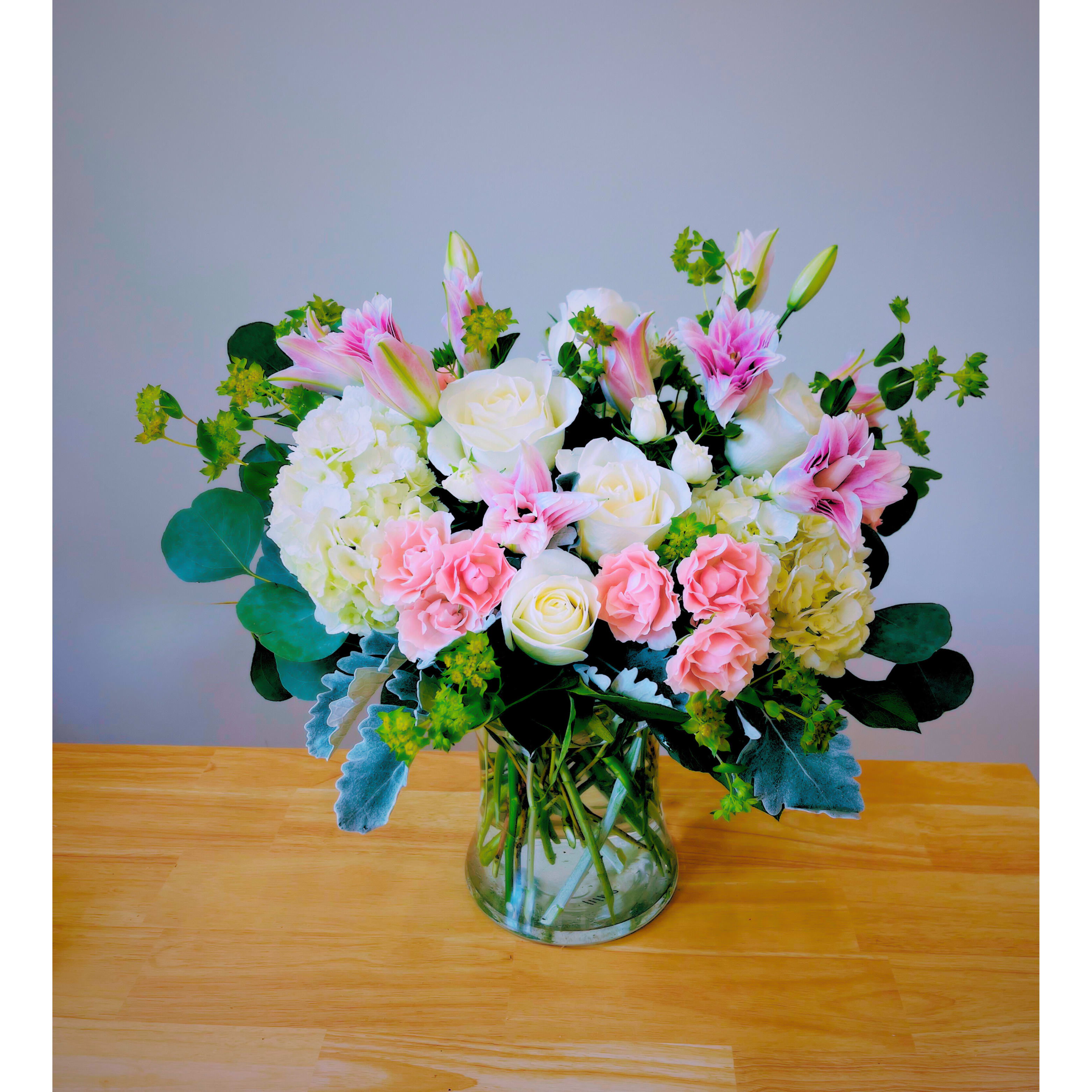 Sweetheart's Romance - A delicate blend of light pink and soft white blooms, and lush greenery. Sweetheart's Romance is the perfect expression of love and affection. With its soft, romantic colors and elegant design, this bouquet is ideal for celebrating special moments with someone you cherish. Simple, beautiful, and full of heart.