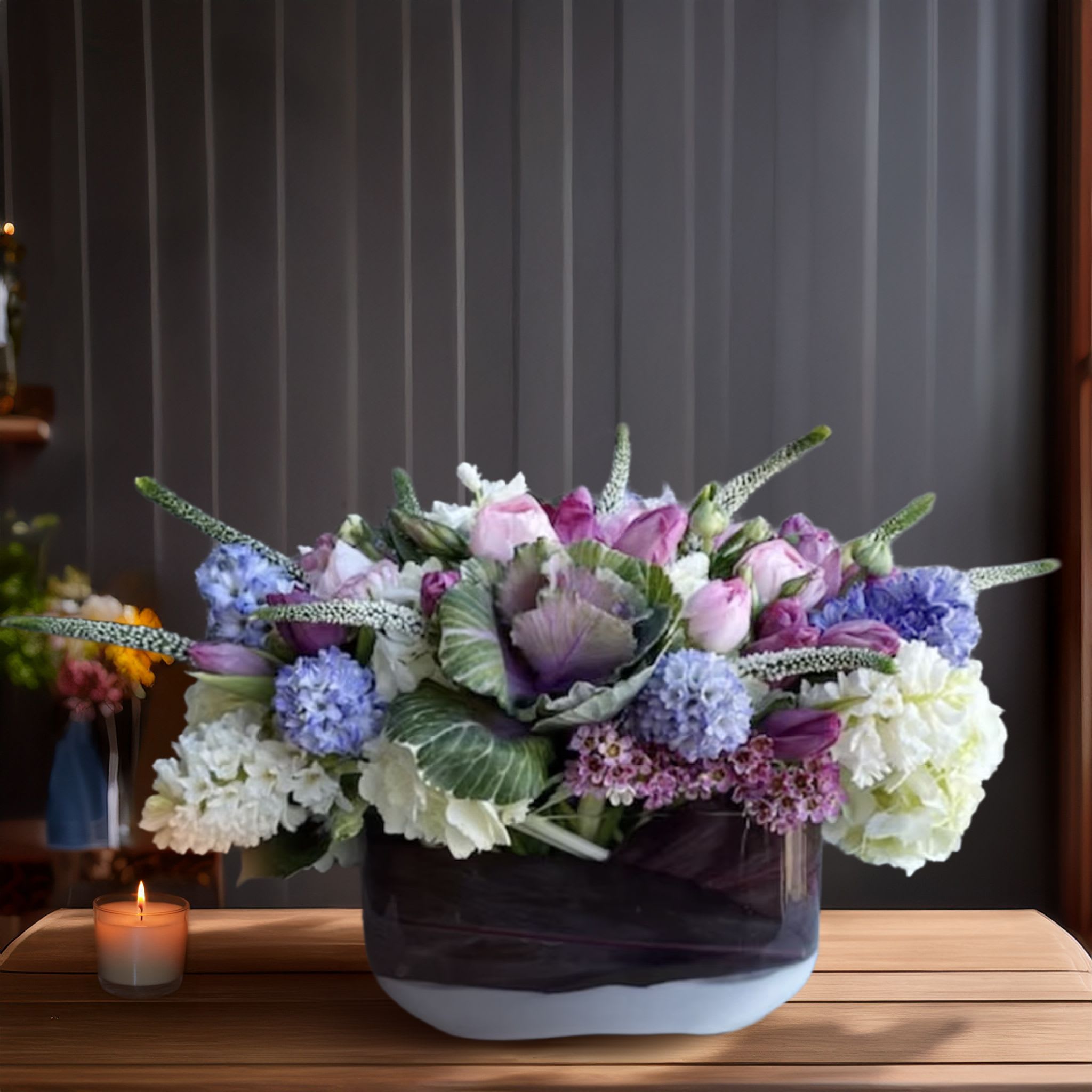 Heaven Scent <3 Heaven Scent <3 - Bold, artistic, and full of layered texture, this one-of-a-kind floral arrangement blends cool-toned elegance with organic drama. Arranged in a two-tone ceramic vessel with a rich plum base and soft white bottom, this composition features a luxurious mix of hydrangeas in cream and periwinkle blue, soft blush roses, lavender tulips, and purple Hyacinth. The star element — ornamental cabbage — adds an unexpected sculptural quality, bringing depth and visual intrigue. Accents of veronica, kale leaves, and premium greenery stretch outward for added shape and movement, creating a design that feels both grounded and expressive. Perfect for fall gatherings, masculine gifting, creative studios, and modern dining tablescapes, this arrangement stands out for its unusual botanical combinations and color-forward design. It’s equally suited for luxury interiors and artistic environments, making it a favorite for clients looking for something nontraditional yet deeply refined. Touch of Orchids LA offers same-day delivery of this specialty arrangement throughout Los Angeles, including Beverly Hills, West Hollywood, Silver Lake, Hancock Park, and Brentwood. This design is part of our Botanical Artistry Collection, curated for clients who appreciate floral work as a form of living sculpture.