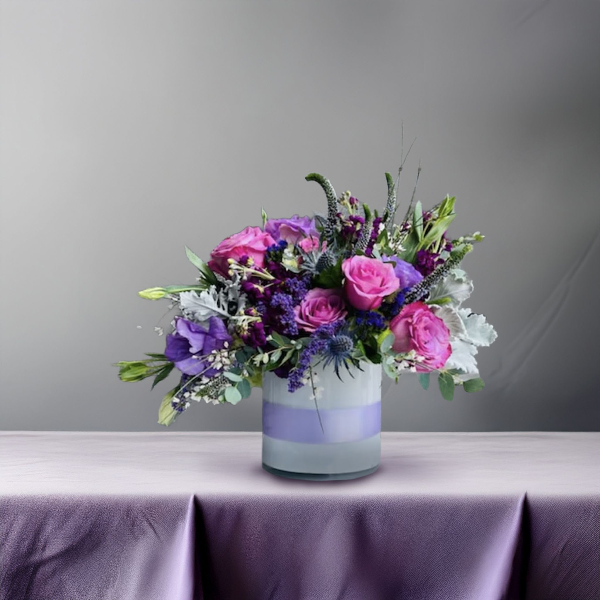 Lavender Passion <3 Lavender Passion <3 - Dramatic, romantic, and richly layered, this purple-toned floral arrangement is a bold expression of elegance and artistry. Designed in a gradient lavender and white glass vase, this striking composition features a luxurious mix of fuchsia roses, deep violet lisianthus, purple carnations, and delicate lavender stock. Accents of Queen Anne’s lace, eucalyptus, and sculptural greenery add movement and contrast, while maintaining a lush, rounded form that feels both elevated and approachable. Ideal for romantic occasions, milestone birthdays, modern dinner parties, or high-end interior styling, this arrangement delivers moody beauty with a designer twist. Its cool-toned palette and compact silhouette make it a versatile piece for statement gifting, elegant home décor, or boutique hospitality settings. Touch of Orchids LA provides same-day delivery of this violet floral design throughout Los Angeles, including Beverly Hills, West Hollywood, Studio City, Brentwood, and Culver City. This piece is part of our Violet Luxe Collection, designed for clients who appreciate floral arrangements with bold hues and refined composition.