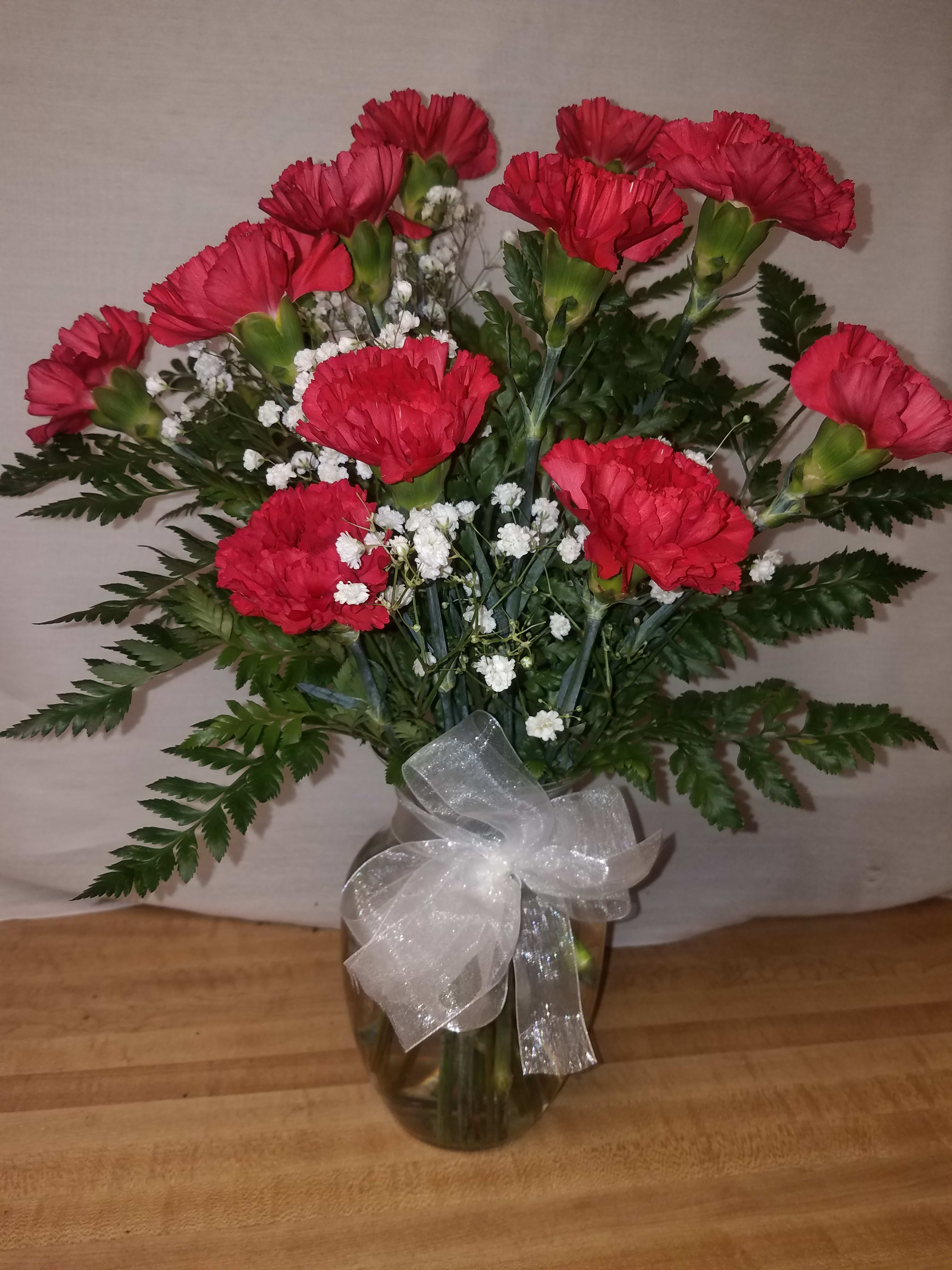 Happy Moments - The classic 12 red carnations in a clear glass vase with babies breath
