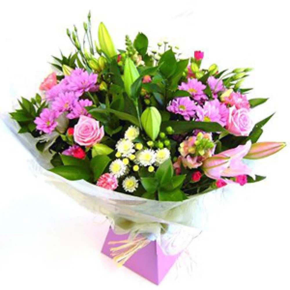 Stunning Handtie - he bouquet in this image features a colorful and lively arrangement of the following flowers: 	•	Pink Roses 	•	Pink Lilies (some still in bud form) 	•	Pink Chrysanthemums 	•	White and Yellow Chrysanthemums 	•	Pink Carnations 	•	Spray Roses (mini roses) 	•	Assorted Greenery (including leaves and unopened buds)  It’s a bright and cheerful combination, perfect for birthdays, congratulations, or simply to brighten someone’s day.