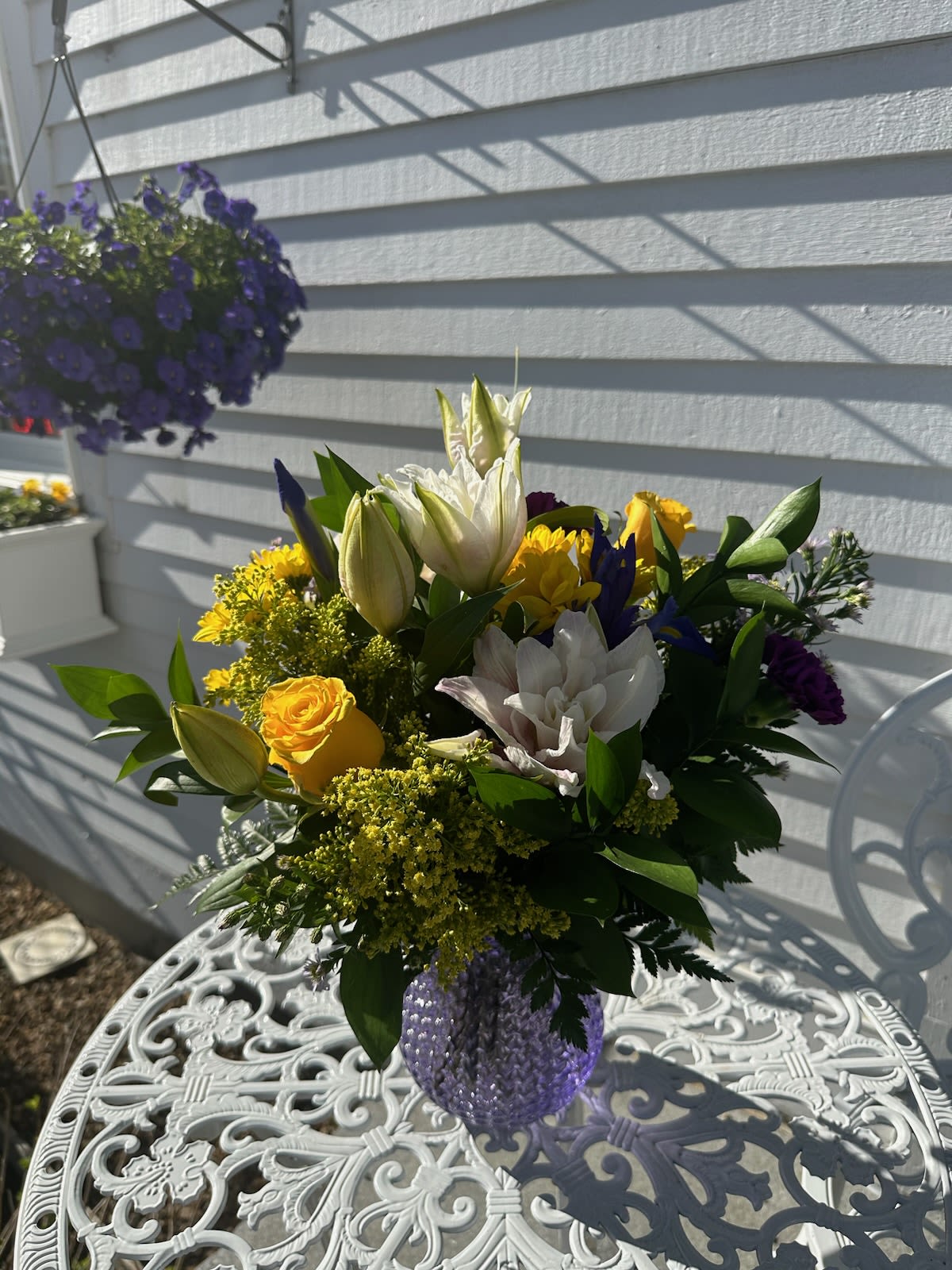 Purple Passion Bouquet - Pink Lilies, Yellow roses, daisies, iris, purple carnations and solidago arranged in a purple glass etched vase