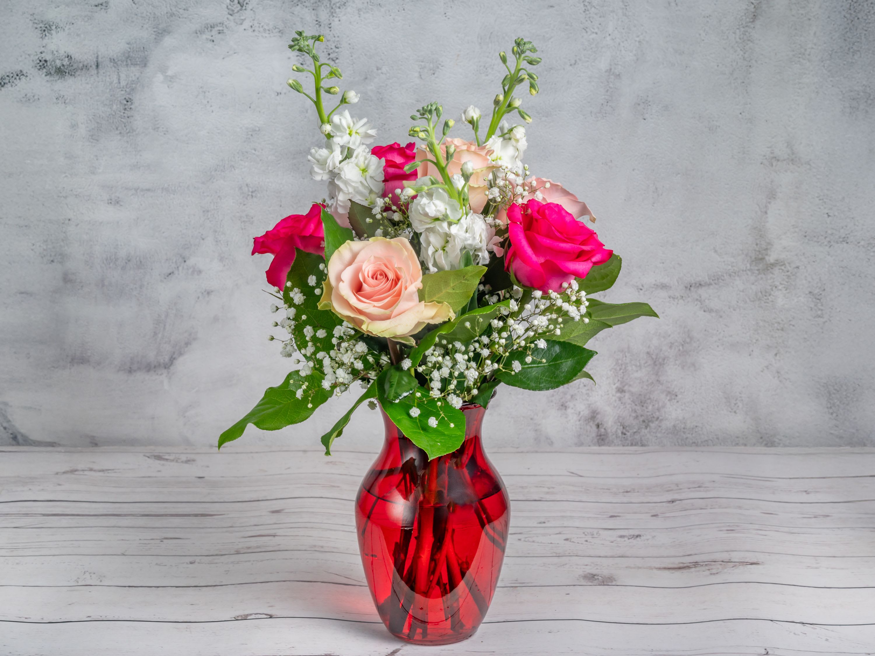 The Chic Pink The Chic Pink - Introducing "The Chic Pink" Bouquet – a delightful arrangement featuring elegant pink roses, soft peach roses, white stock, and delicate baby's breath, surrounded by fresh greenery. Presented in a sleek, ruby-red vase, this bouquet adds a touch of romance and sophistication to any setting. Perfect for expressing love, admiration, or simply brightening someone's day with its classic charm and graceful hues. Make any moment special with this timeless floral gift.