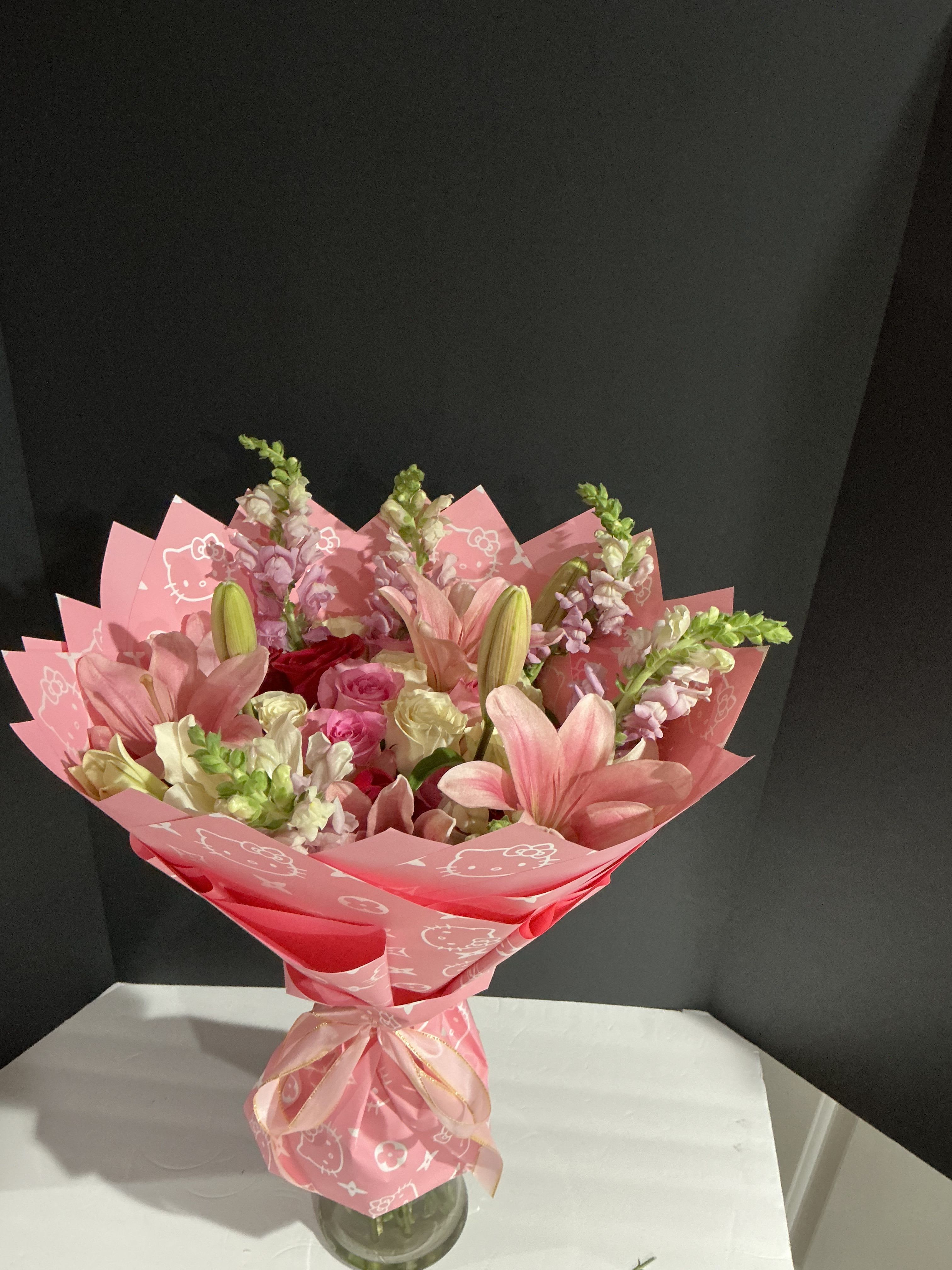 Sweet pinkish bouquet - This bouquet was made with soft pink color following the season’s trend, covered with Korean paper to surprise in any special ocassion    Rosas,lilies snapdragon hello kitty korean paper (no base incluid)