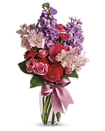 Jumping For Joy Jumping For Joy - Send her on a dreamy stroll through a garden with this perfect-for-any-occasion bouquet. Soft lavender and pink flowers delight with a sweet smell; a pink ribbon adds to the feminine look of this traditional arrangement. Approx. 10 1/2 W x 17 1/4 H Lush lavender stock, pale pink alstroemeria, hot pink spray roses and mini carnations are delivered in a traditional glass vase adorned with a pink ribbon. Orientation: All-Around