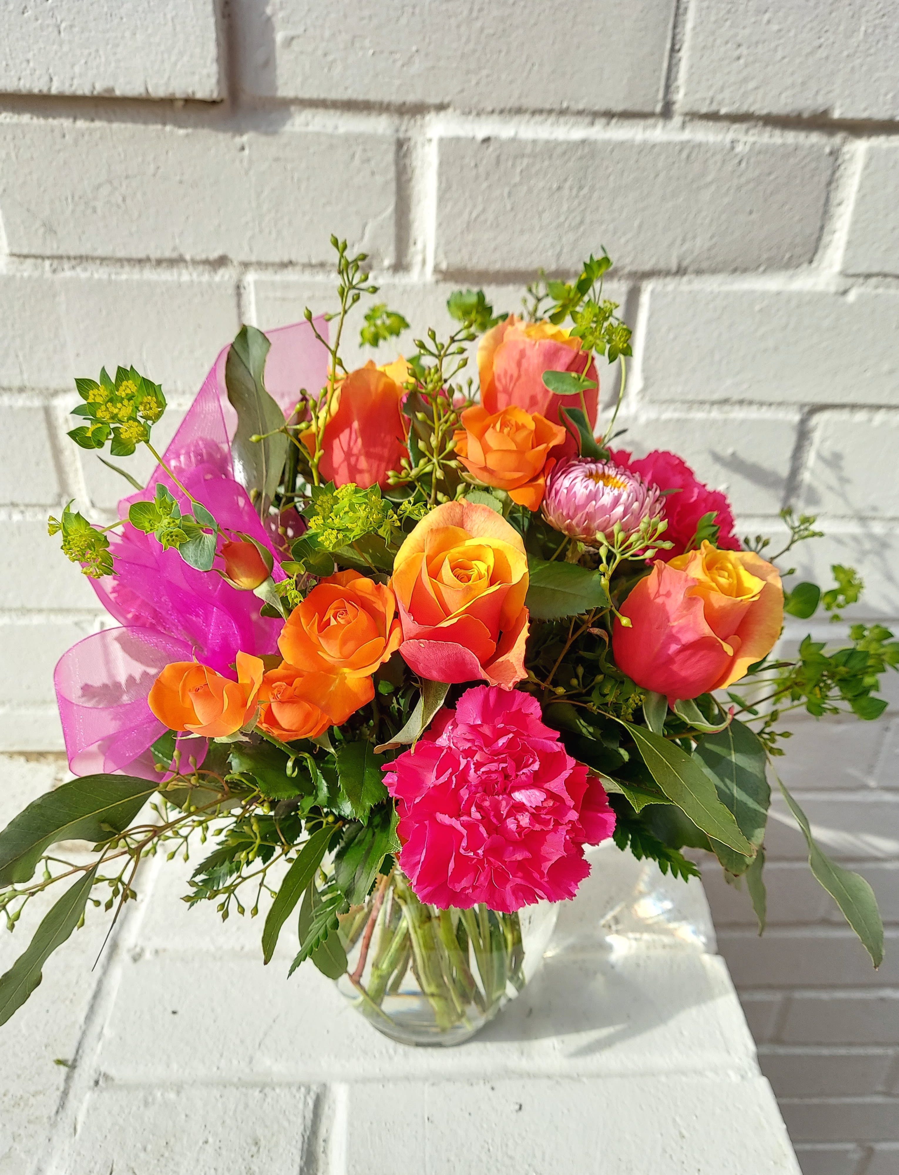 Cherry Brandy Cherry Brandy - Oranges and Pinks bouncing off of one another make up this bouquet FULL of personality. Roses and carnations are mixed with seasonal goodies to create a well balanced design. Approximately: 9"T x 8"W