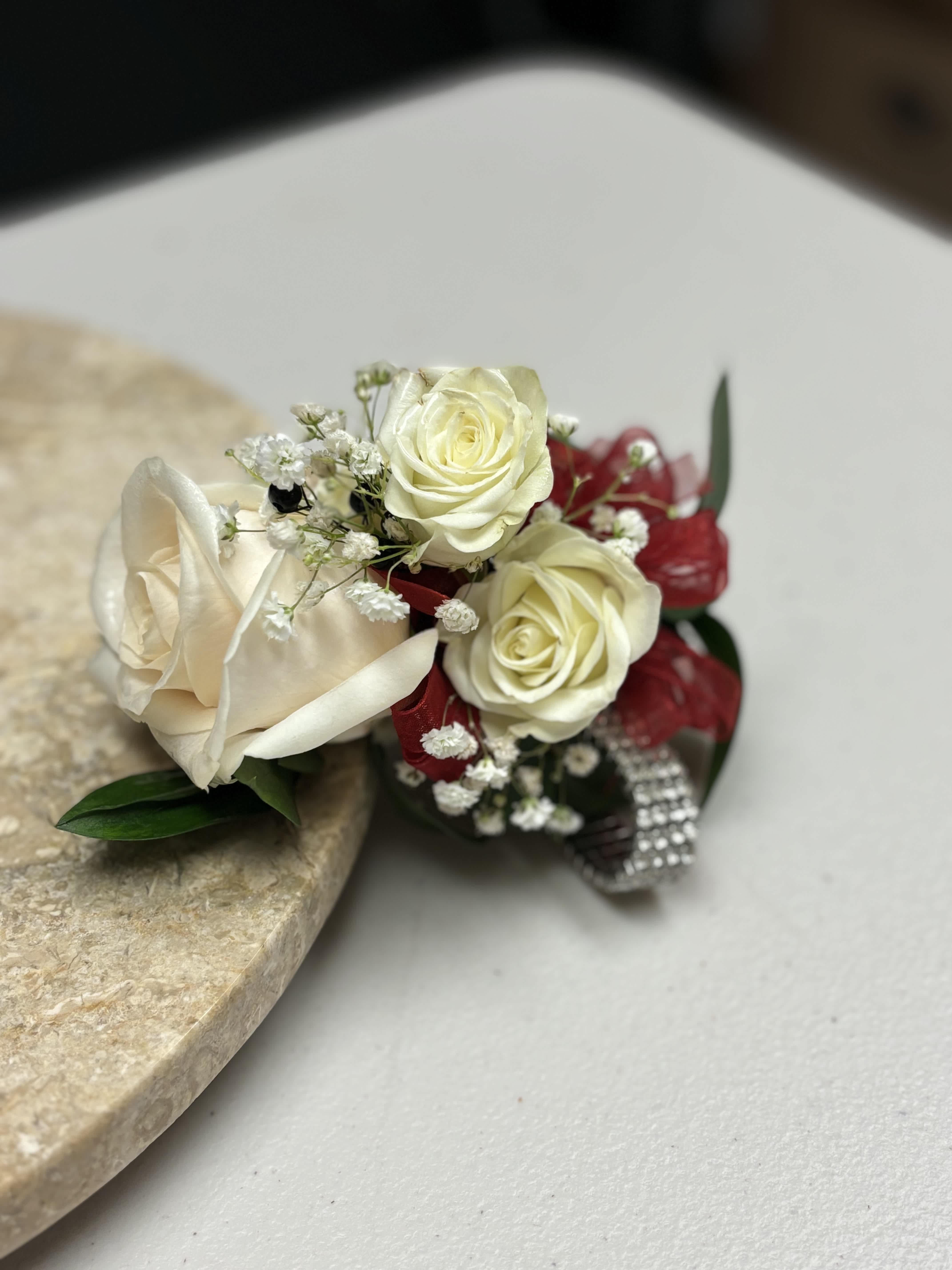 White Rose Wrist Corsage White Rose Wrist Corsage - Ivory rose wrist corsage for prom or special events. Wrist corsage includes ivory rose, spray roses, baby's breath and greenery with ribbon color of your choice. Perfect for prom or special occasions.