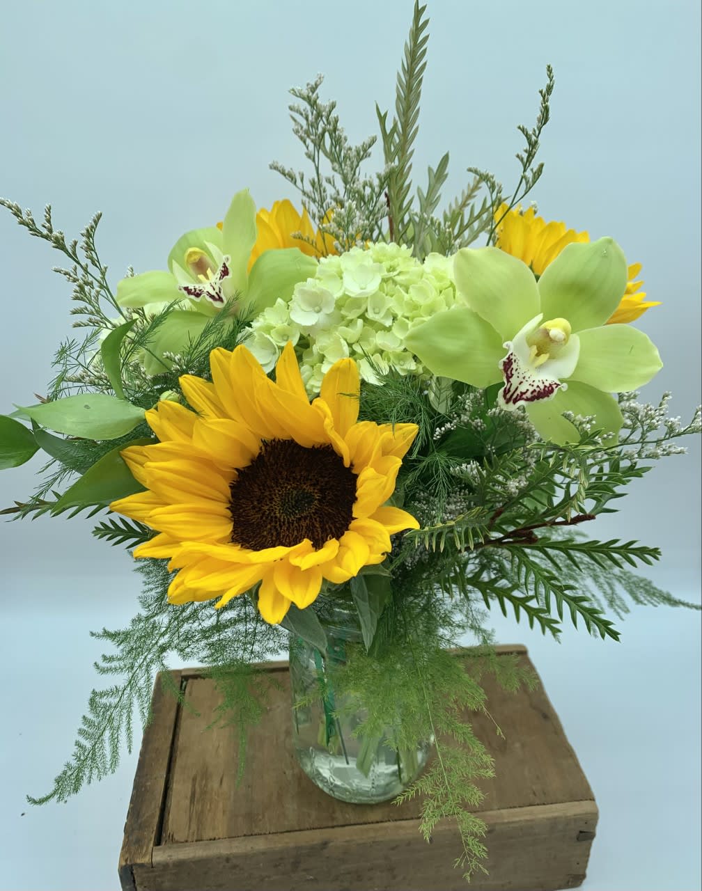 A Little Sunshine  - This cheerful vase design features Sunflowers, mini green hydrangeas and cymbidium orchids.   