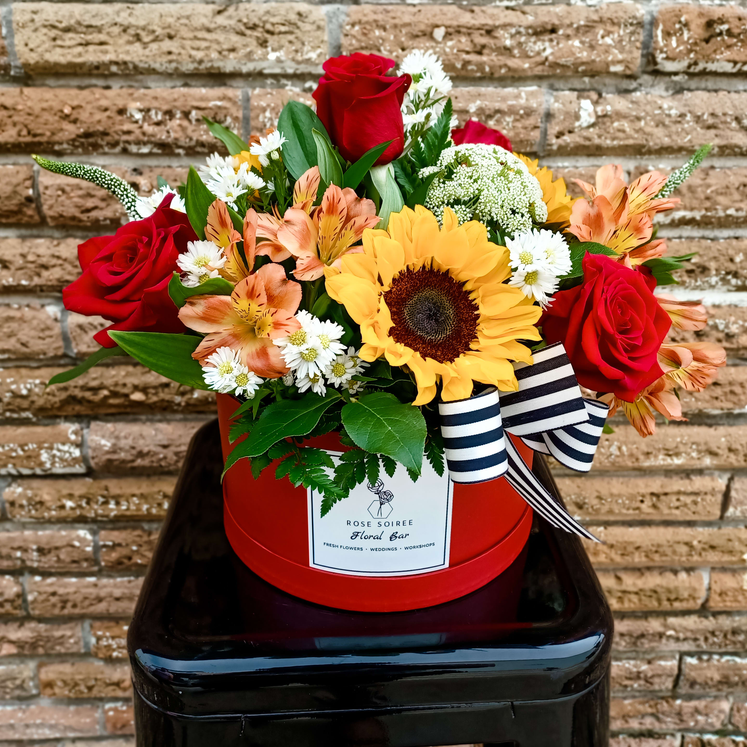Sunshine and Roses - Spread some happiness wherever you send this gorgeous box featuring  Sunflowers  and Red Roses and a mix of complimenting flowers, overflowing with lush greenery.