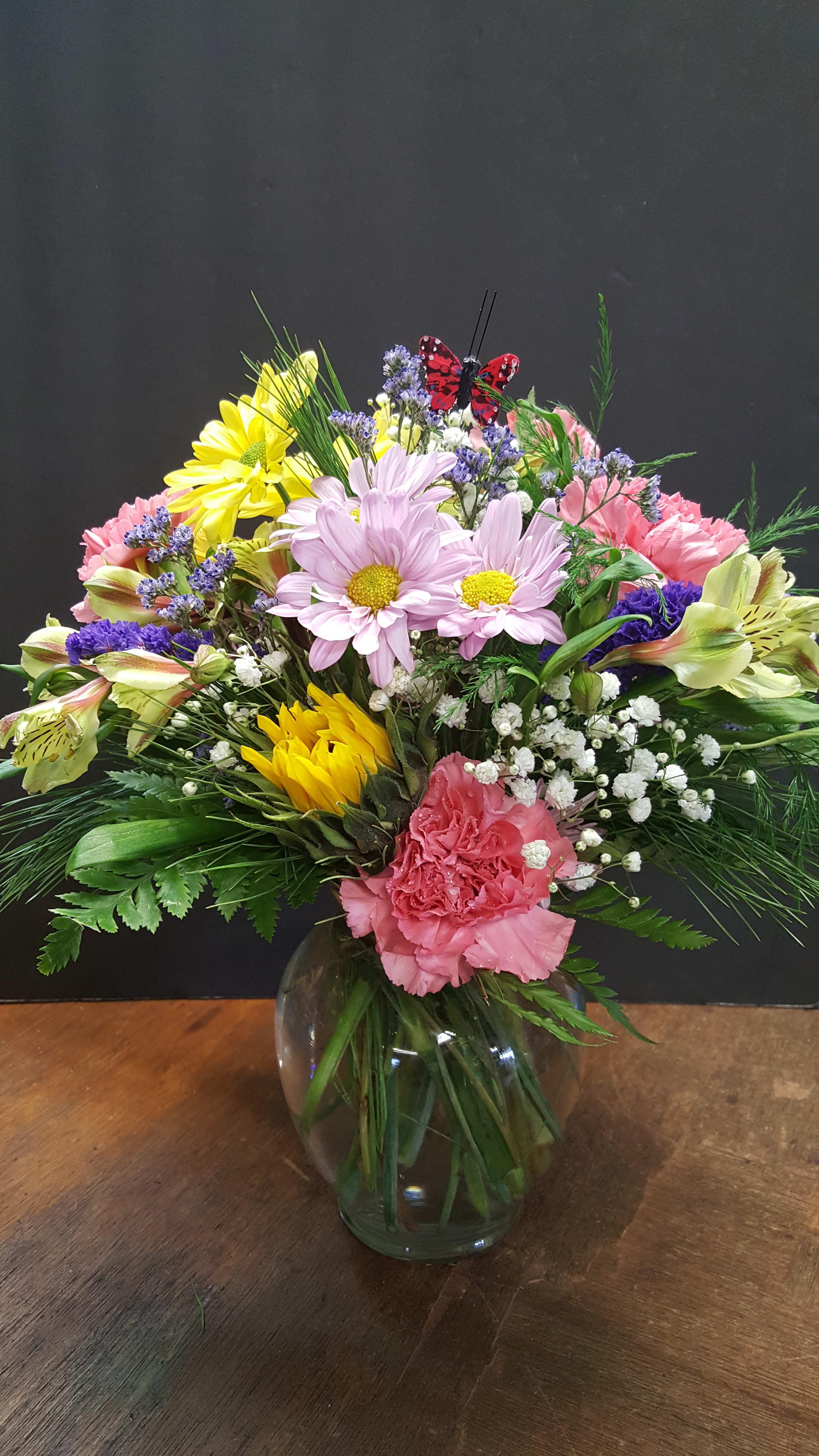 Petite & Sweet Petite & Sweet - Small/Petite circular cluster of flowers based on inventory at time of order. This design, with butterfly is an add-on purchase at time of purchase? Standard in photo! 4" clear glass vase! The colors & variety of flowers will vary at times. FULL value of course!