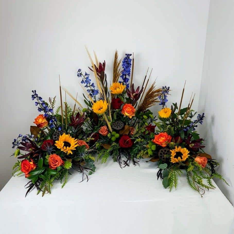 Sunflower summer urn piece - This urn piece is stunning with the sunflowers, delphinium and roses.  The wheat, cattails, pods and grasses are a nice natural accent.  