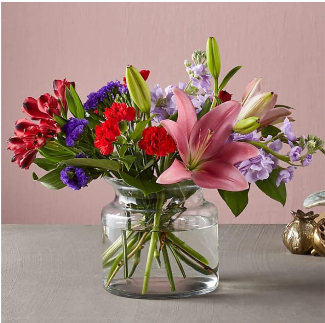 Romantique Bouquet - This fresh take on the classic Valentine's Day arrangement is just the bouquet to have your special someone swooning. Full blooms like lilies and roses take center stage in our Romantique Bouquet, while bold purple statice and dainty lavender stock spill out to add a bit of drama.  Please Note: The bouquet pictured reflects our original design for this product. While we always try to follow the color palette, we may replace stems to deliver the freshest bouquet possible, and we may sometimes need to use a different vase. DETAILS The Premium Bouquet is about 18&quot;H x 22&quot;W. Designed by florists, ready to display. For long–lasting blooms, replace the water daily. We suggest trimming the stems every couple days. Pet Safety Precautions: This bouquet or plant may include flowers and foliage that are known to be toxic to pets. To keep them safe, be sure to keep this arrangement out of your pet's reach.