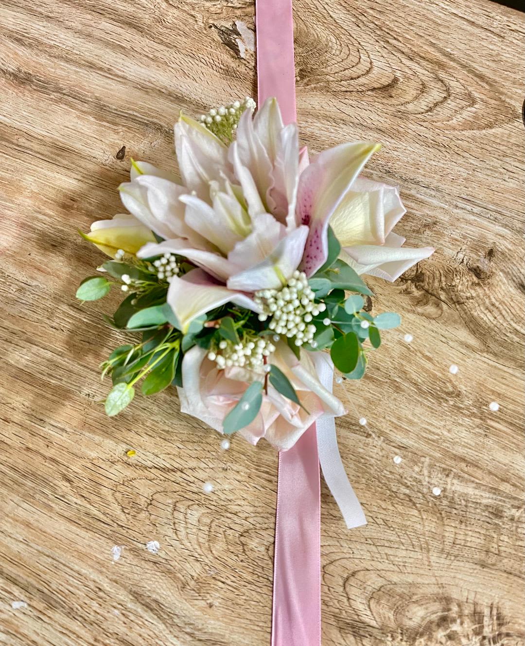 Joyful Flora Corsage - Made from fresh flowers, a corsage looks like a petite flower arrangement (typically consisting of just one or several smaller blooms) and usually sits on the wrist like a bracelet, though it can also be pinned on a lapel. Corsages serve as a way to honor people who are very important to the couple getting married. Please contact our shop at (747) 249-4678 for any customization. 