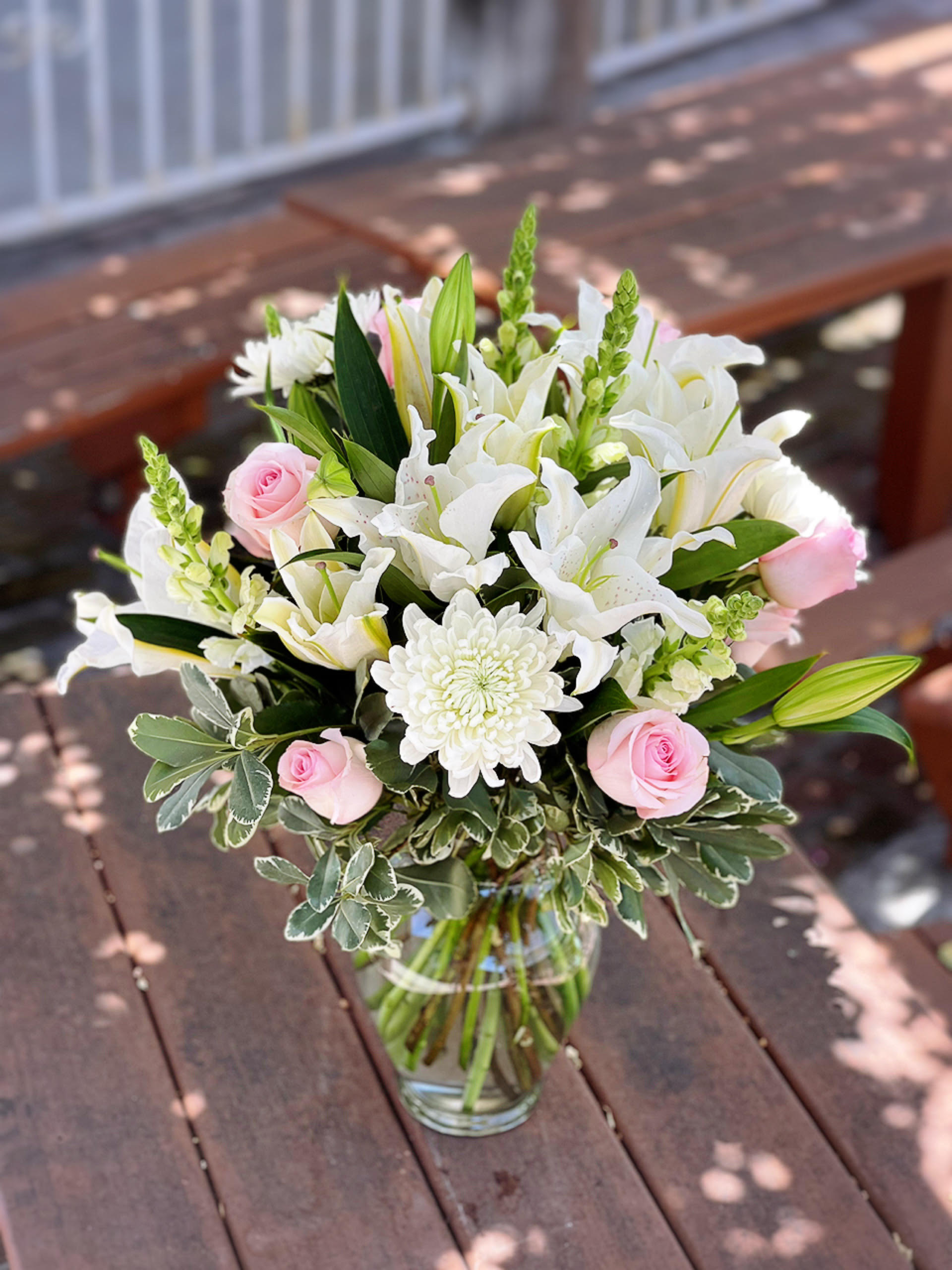 Just Because Just Because - - 3 White Lilies - 6 Pink Roses - 5 Stems White Snapdragons - 4 Stems White Spider Mums - Greenery - 11 Inches Garden Rose Vase