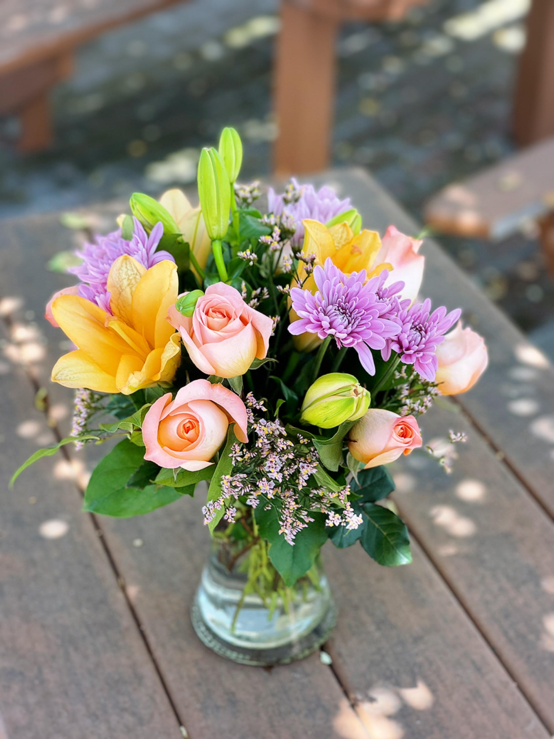 Weekly Special Arrangement 2 Weekly Special Arrangement 2 - - 2 Stems Orange Lilies - 3 Lavender Daisies - 6 Stem Orange Roses - Fillers - Greenery - 8 inches Gathering Vase