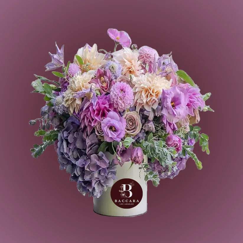 Lavender Dreams: Purple & Lavender Floral Arrangement Lavender Dreams: Purple & Lavender Floral Arrangement - Immerse yourself in the calming energy of summer with our Lavender Dreams floral arrangement! Featuring an exquisite blend of deep purple blooms and soft lavender hues, this enchanting display captures the essence of sunlit gardens and serene evenings. Each flower radiates warmth and tranquility, making it the perfect centerpiece for summer gatherings or a soothing addition to your home. Let the soothing colors and delightful scents transport you to a blissful summer escape, where every day feels like a celebration! Disclaimer: Product images are for reference only. Actual flower shades, box colors, and arrangement styles may vary slightly based on seasonal availability and stock. We always strive to match the overall style, color palette, and quality shown in the photos, ensuring every arrangement is fresh, beautiful, and thoughtfully curated.