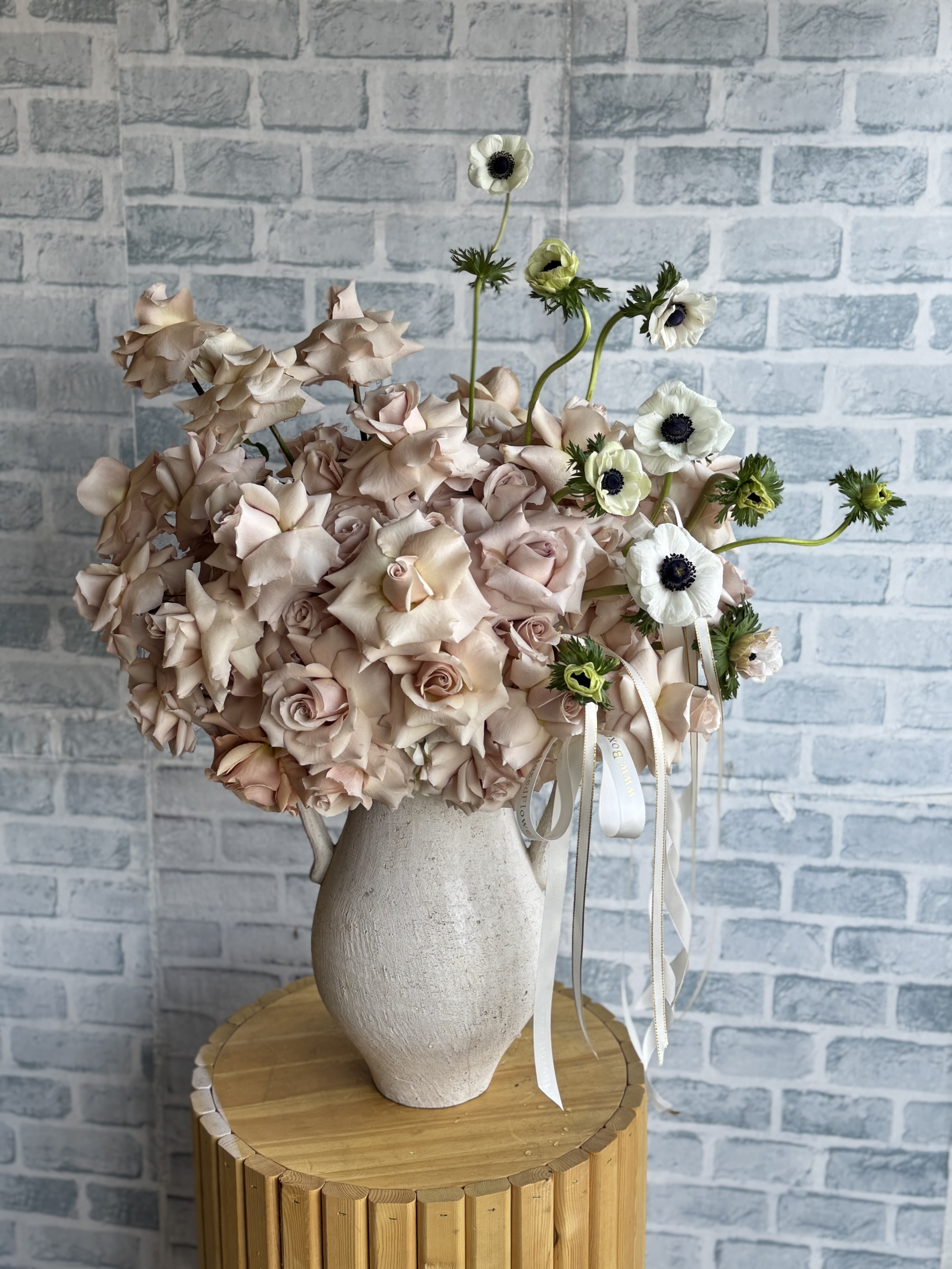 Simply elegant jug vase - A jug shaped vase in the neutral towns accompanied with quicksand nude roses and white anemones. 