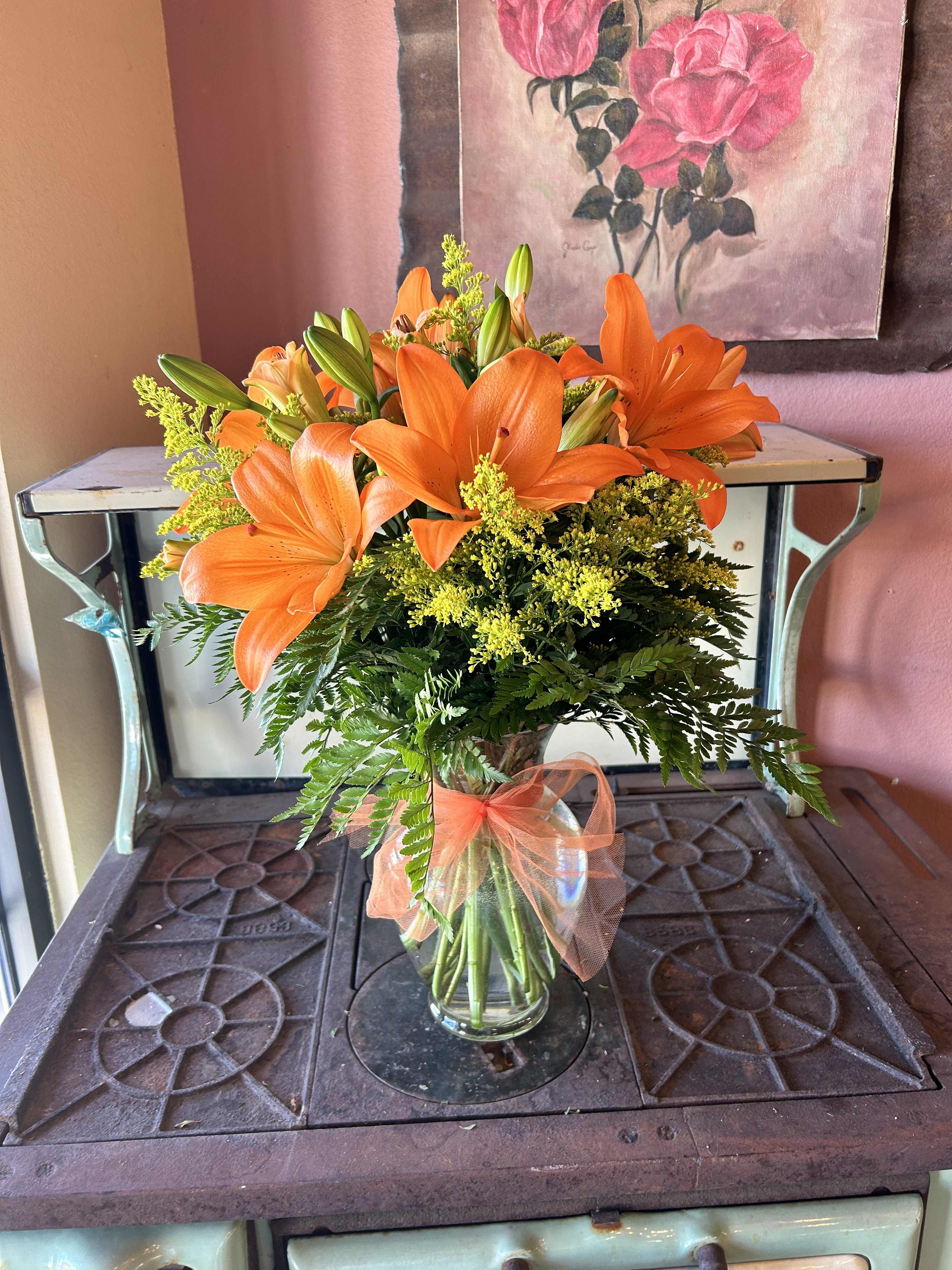 Sunrise Lilies Sunrise Lilies - The gift of a beautiful morning sunrise represented in these lilies is like that first sip of coffee in the morning. Filled with lilies and solidago in a clear vase will brighten any loved ones heart.